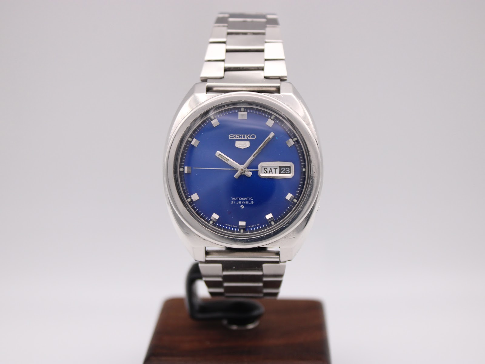 Front-on view of the Seiko 6119-8273 automatic watch on a display stand, showcasing its vibrant blue dial and stainless steel case.