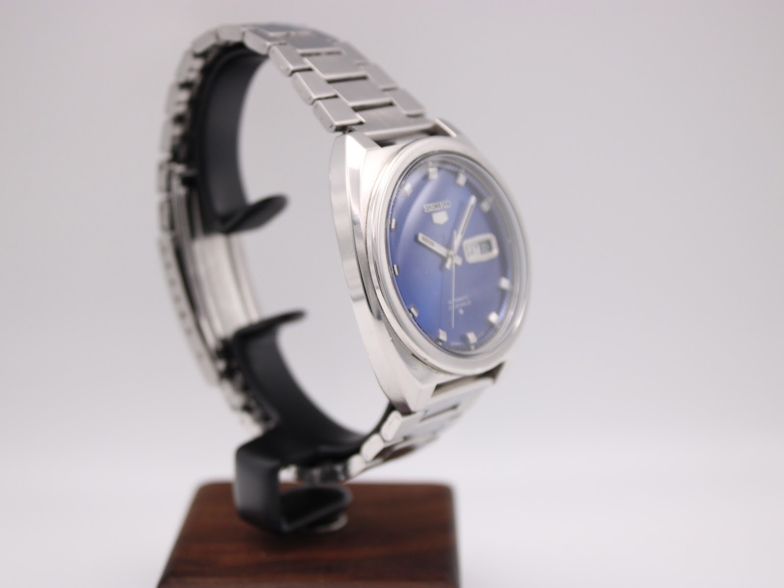 Another angled side view of the Seiko 6119-8273 on a stand, showing the integrated stainless steel bracelet.