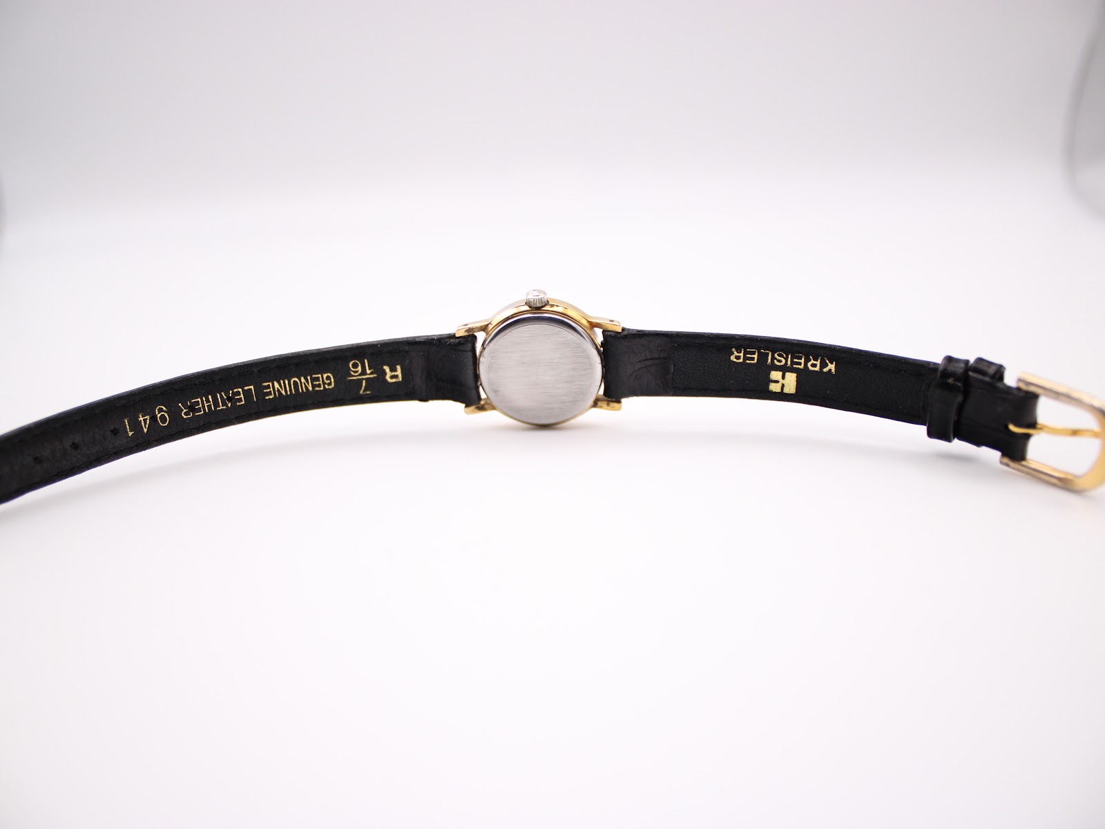 View of the watch from the back, showing the stainless steel case back and the inside of the black Kreisler leather strap.