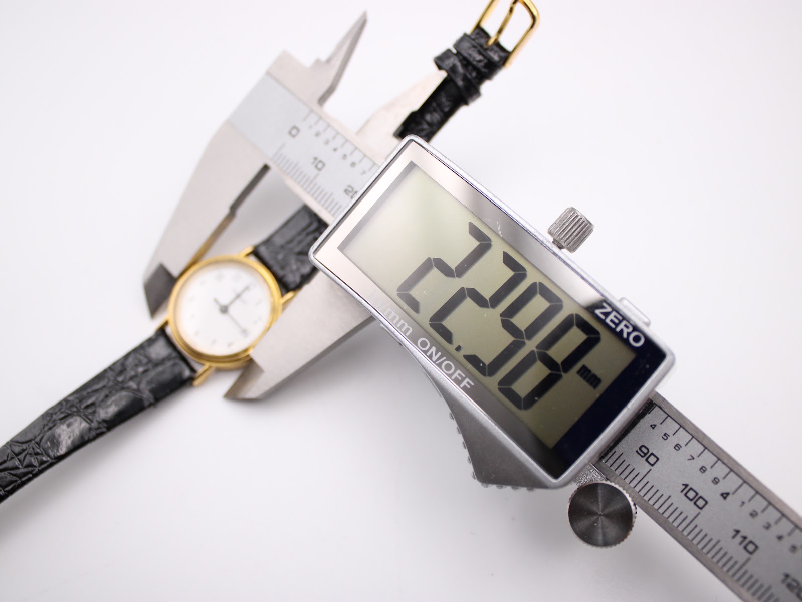 Close-up of a digital caliper measuring the Tissot C 212 watch case diameter at 22.98mm.