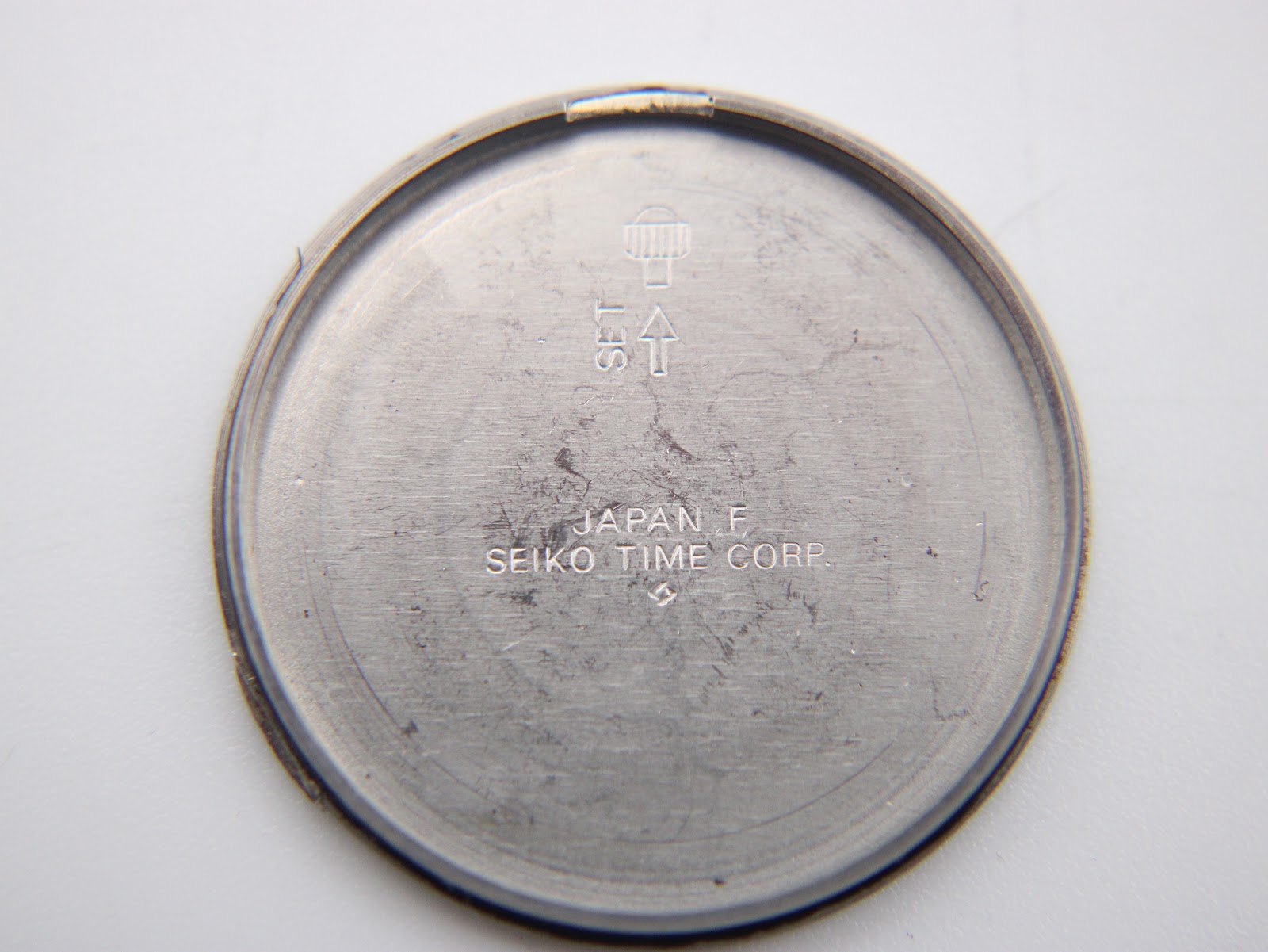 Close-up of the inner side of the stainless steel case back, engraved with 'Japan F Seiko Time Corp.'.