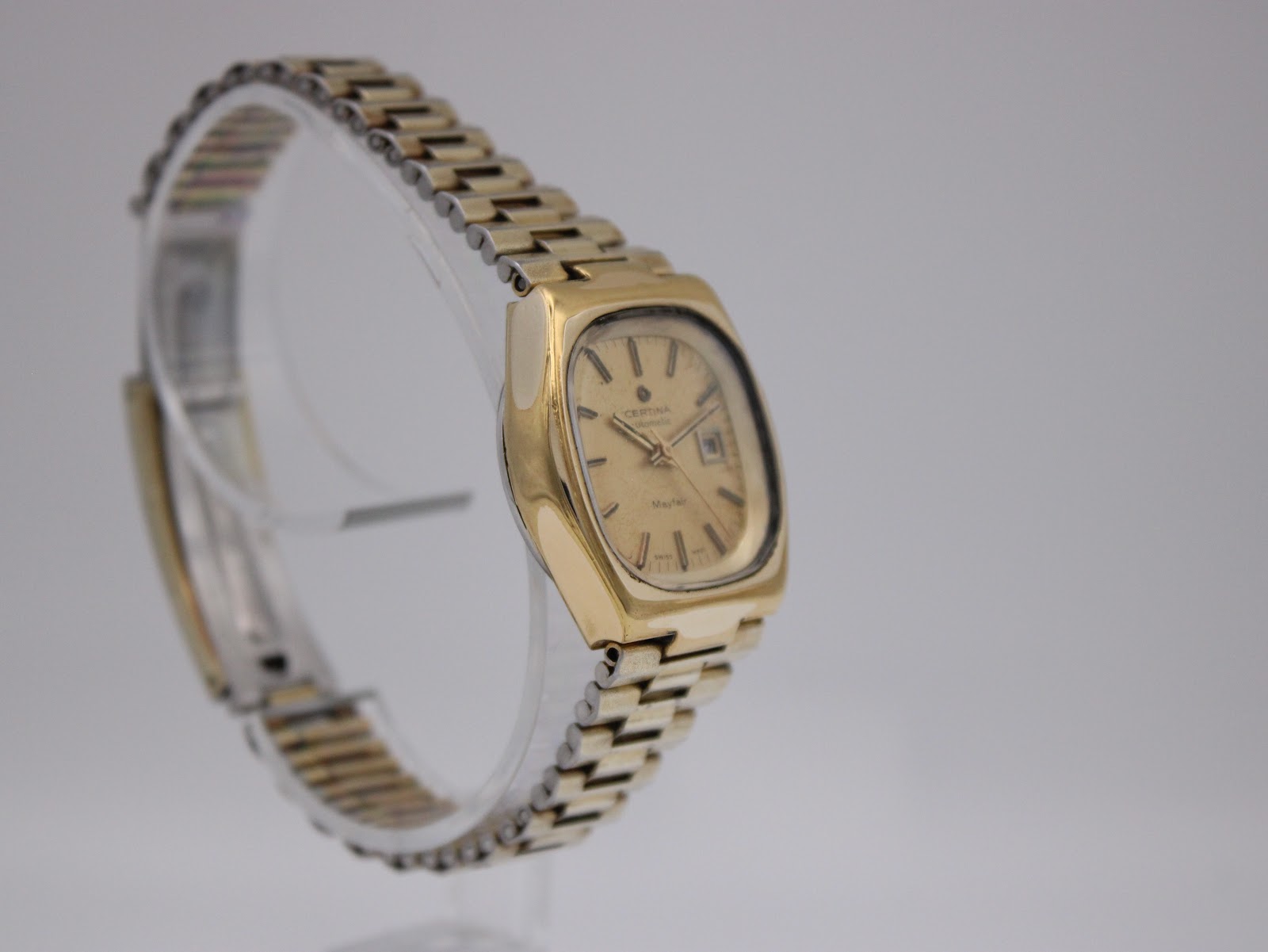 Oblique side view of the vintage Certina Mayfair watch, showcasing the full gold-plated steel bracelet and case shape.