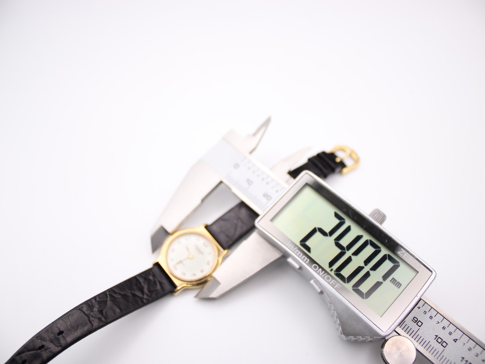 Digital caliper displaying 24.00mm, measuring the case diameter of the watch.