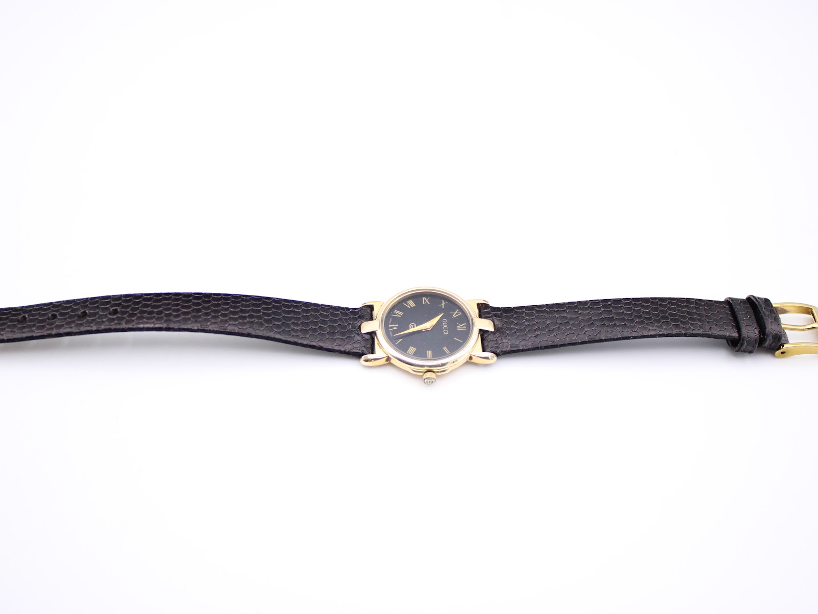 Full length view of the Gucci 3400 L watch with its black textured leather strap extended.