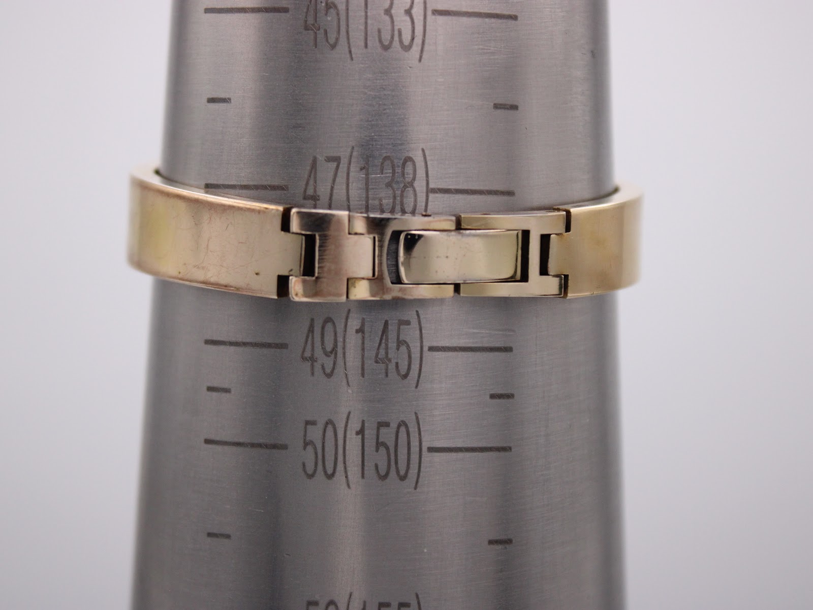 The watch's integrated bracelet measured on a wrist sizing cone, indicating a circumference of approximately 13.8cm.