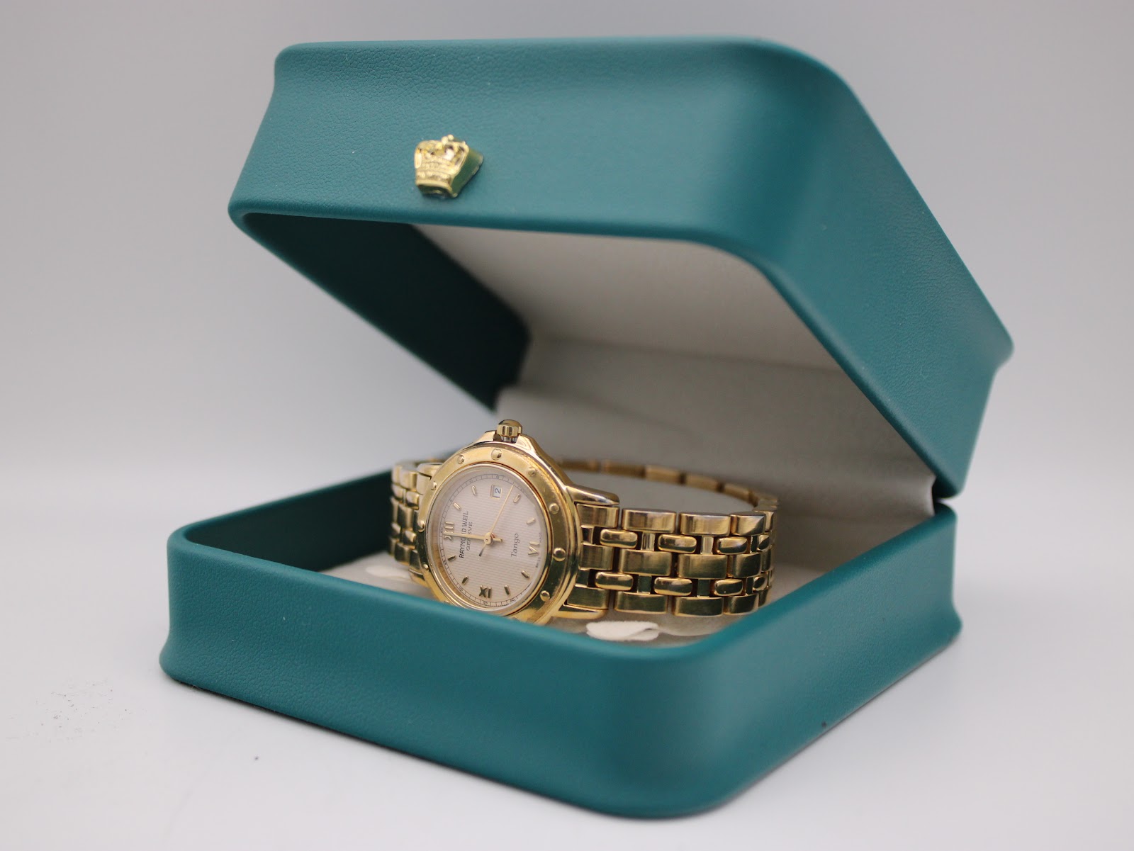 The Raymond Weil Tango watch presented open in a teal generic display box.