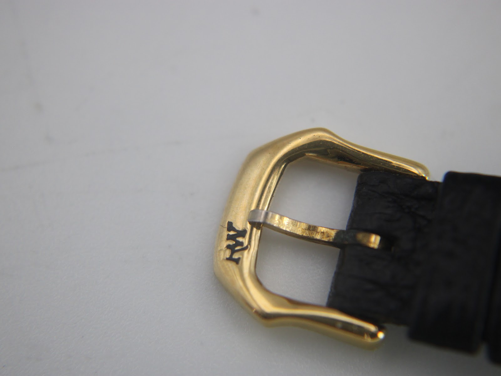 Close-up of the gold-tone buckle, clearly showing the 'RW' brand logo.