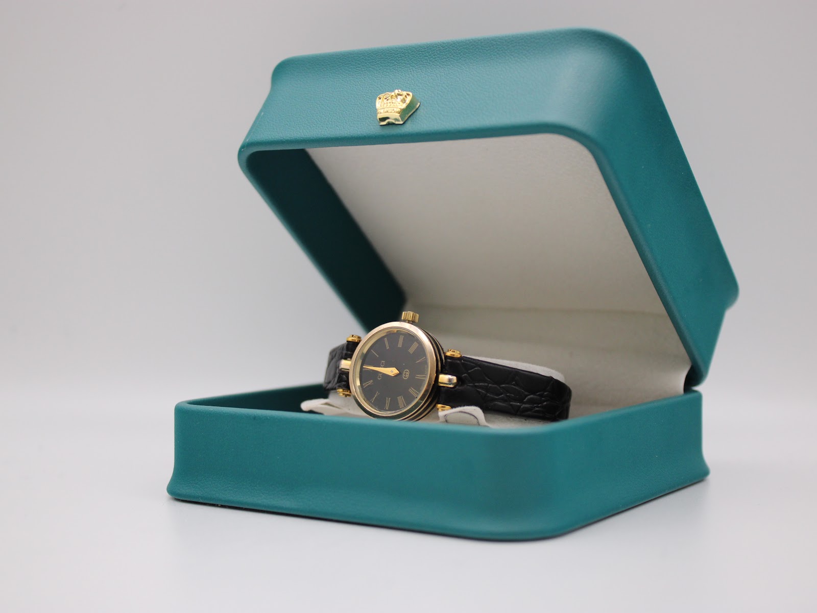 Angled view of the Gucci 2000L watch resting inside an open turquoise display box with a crown emblem.