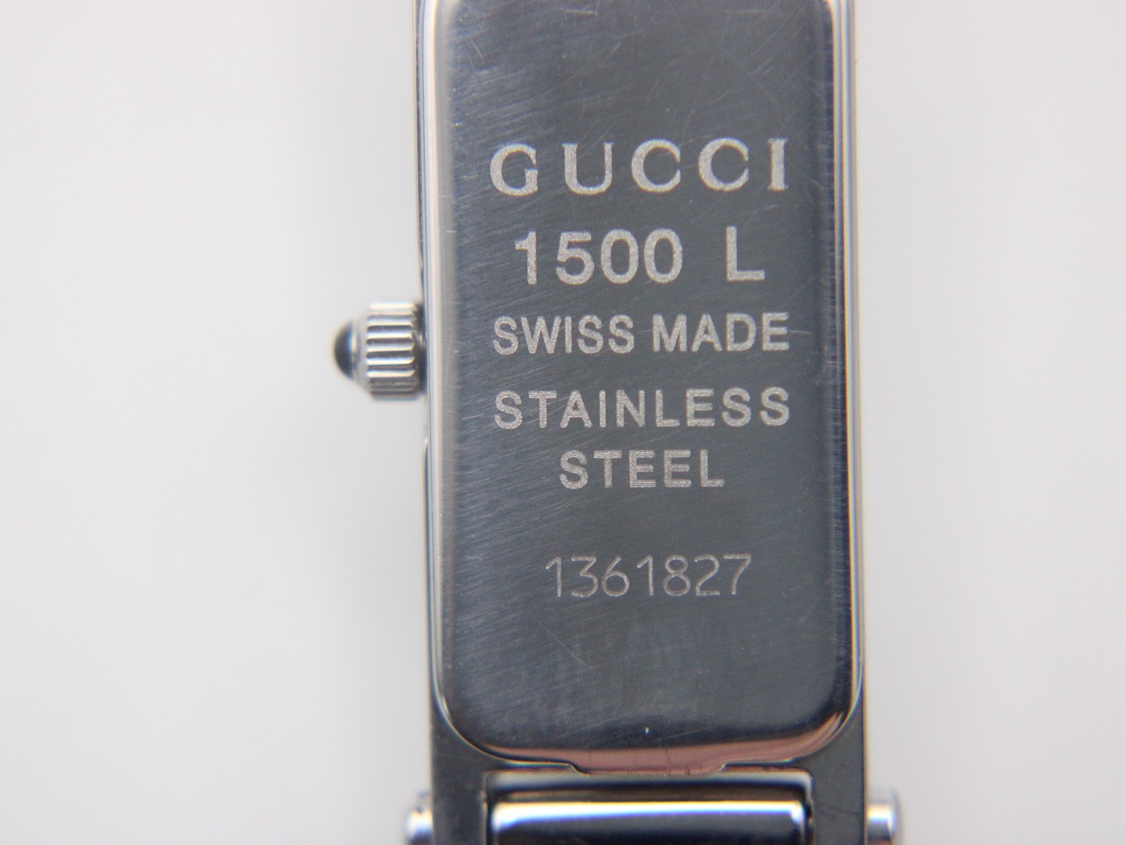 Close-up of the watch case back, engraved with "GUCCI 1500 L", "SWISS MADE", "STAINLESS STEEL", and the serial number "1361827".