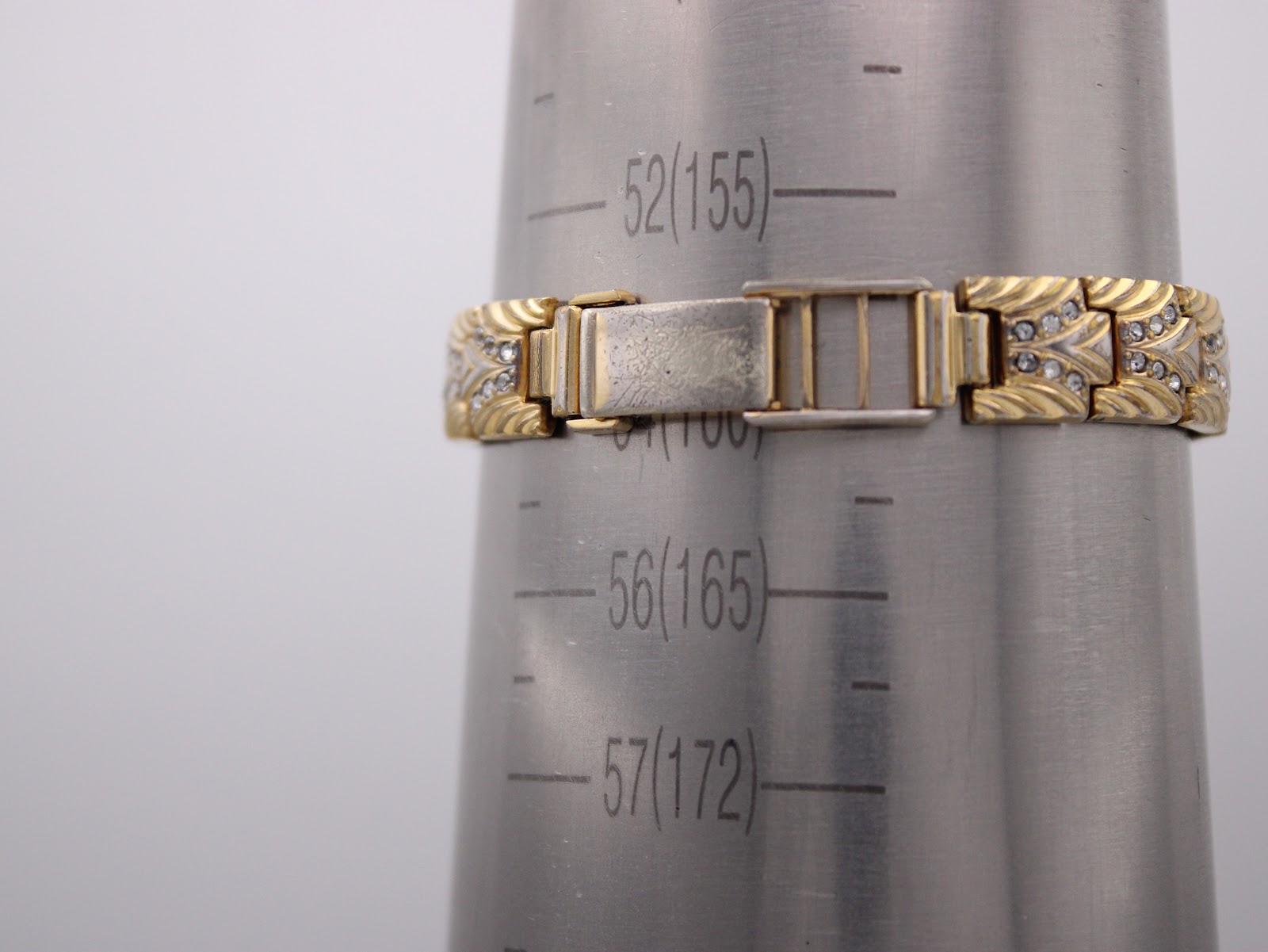 Close-up of the Bulova watch bracelet clasp on a wrist sizing gauge, indicating a wrist size of approximately 15.5cm.