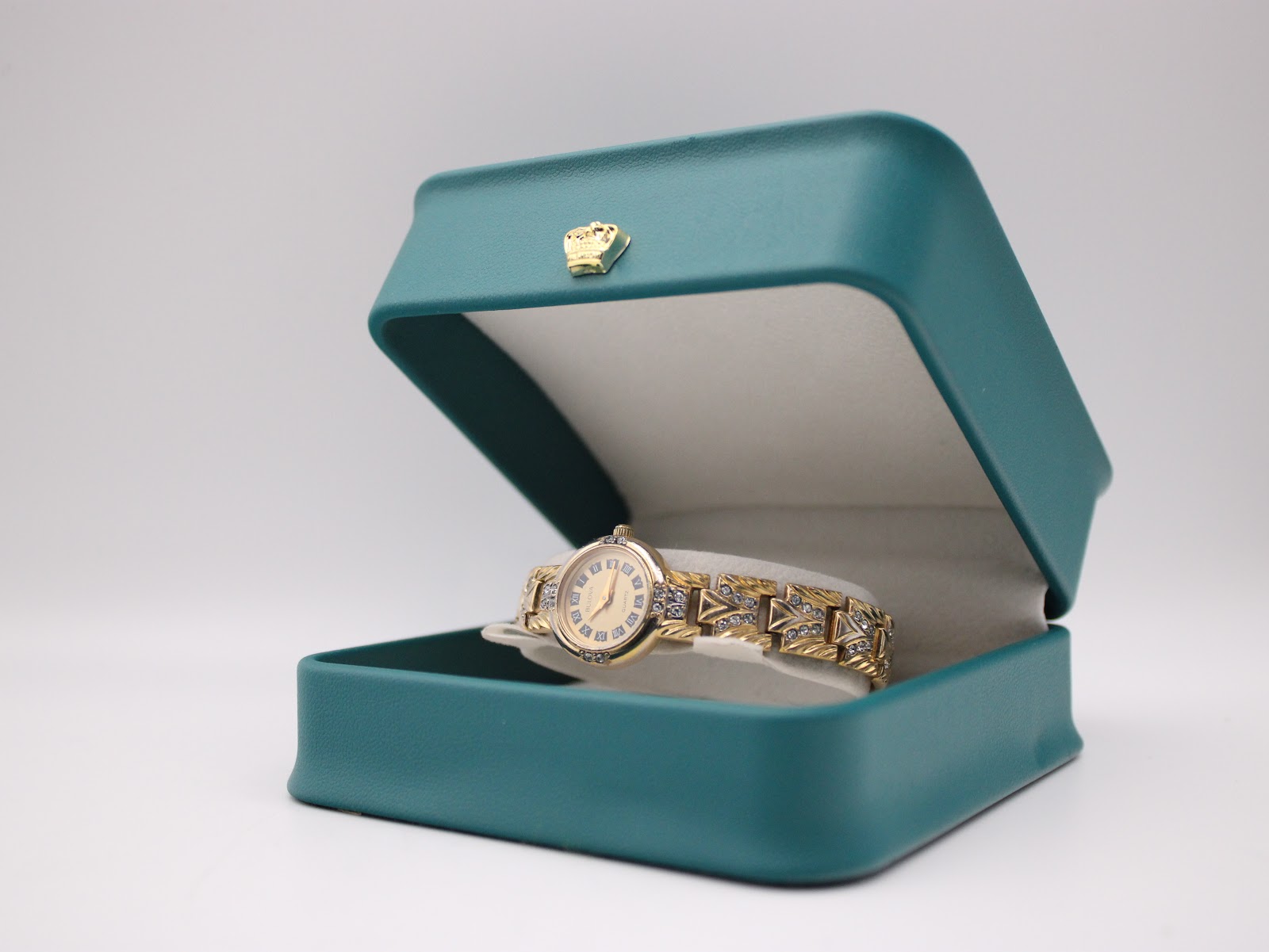The Bulova ladies' watch displayed inside a small, open teal gift box with a gold crown emblem.