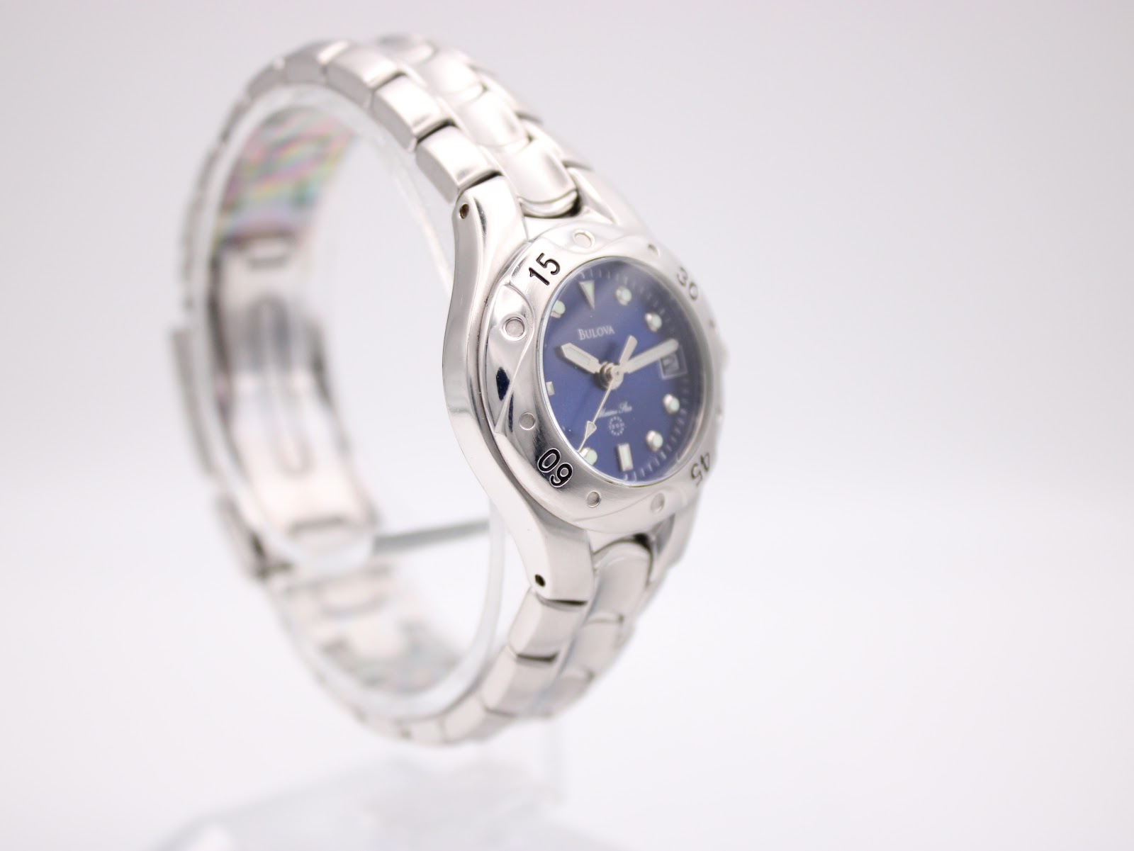 Alternate side profile view of the Bulova Marine Star watch, showcasing the case shape and bracelet links on a clear stand.