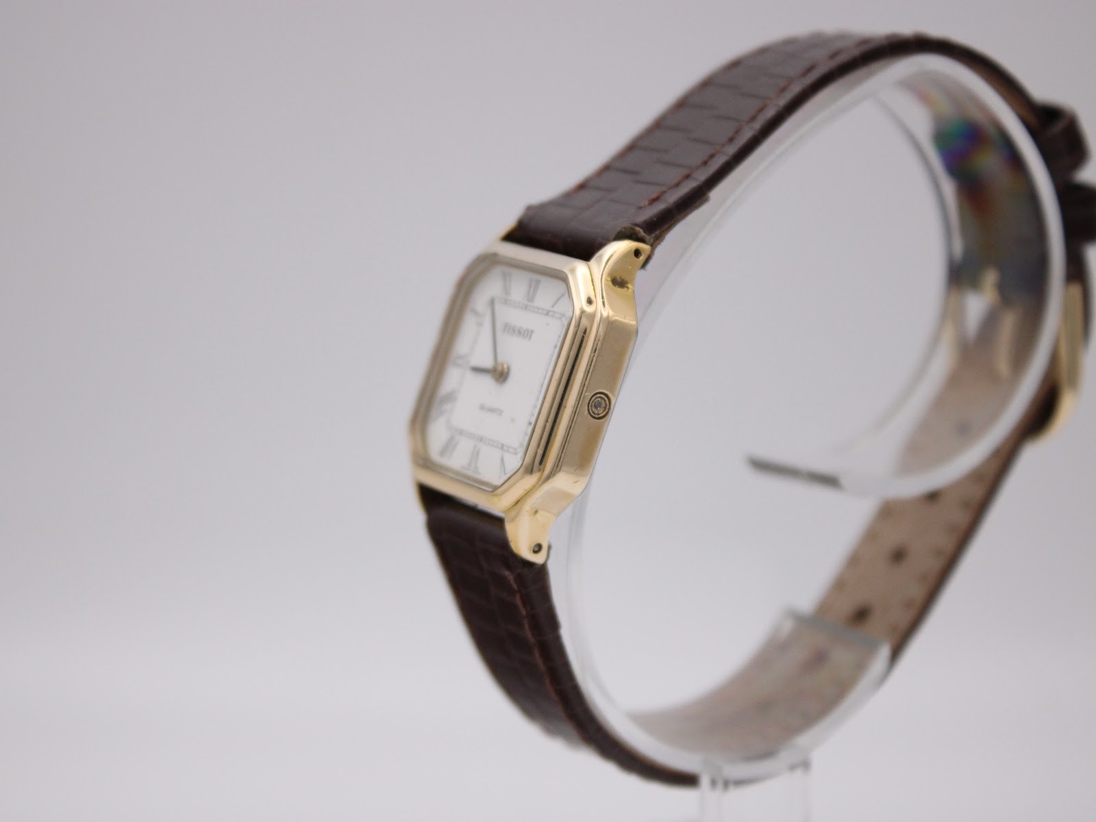 Side view of the Tissot 21589 gold-coloured case, showing the integrated hidden electronic crown.