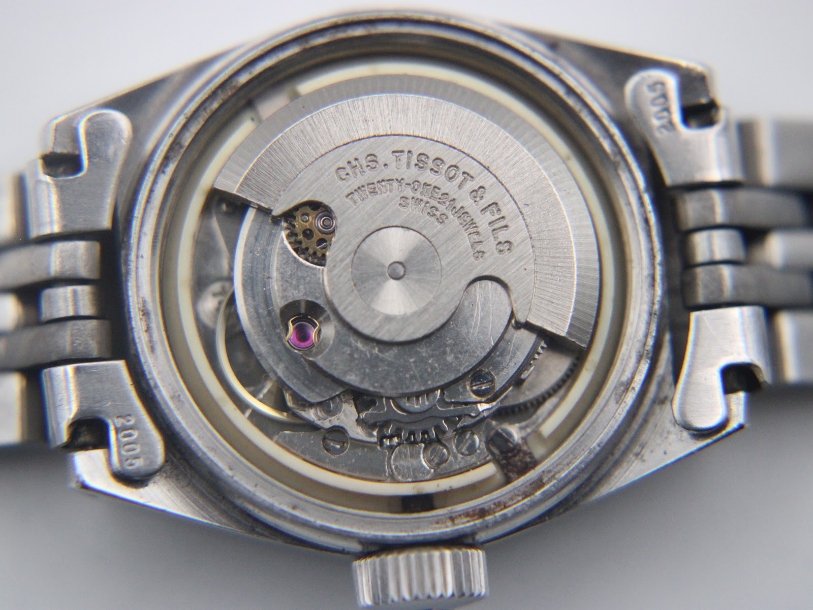 Detailed view of the Swiss automatic movement inside the Tissot PR 516, showing the rotor, twenty-one jewels, and 'CHS. TISSOT & FILS' engraving.