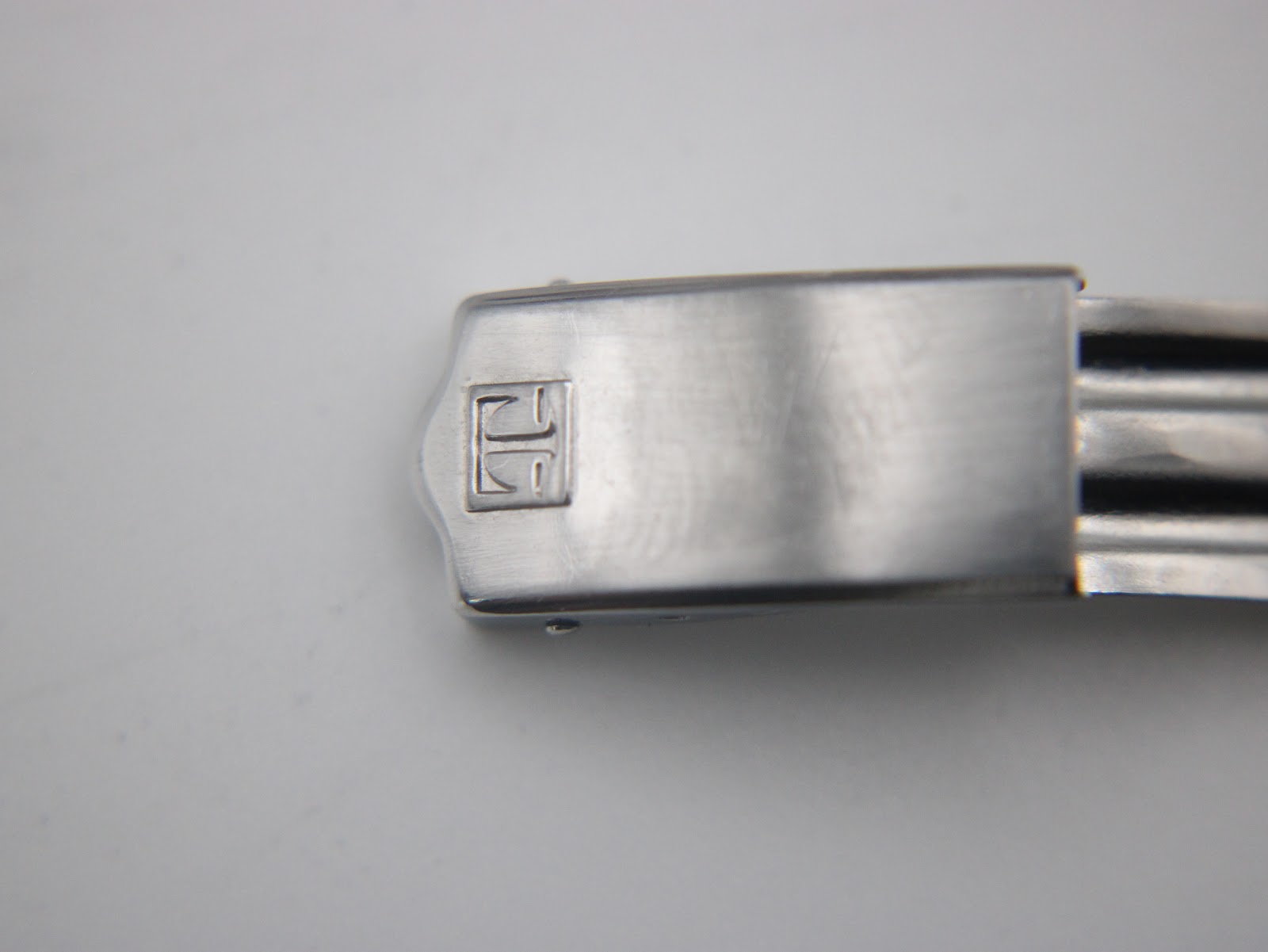 Close-up of the integrated bracelet's folding clasp, clearly showing the Tissot 'T' logo.
