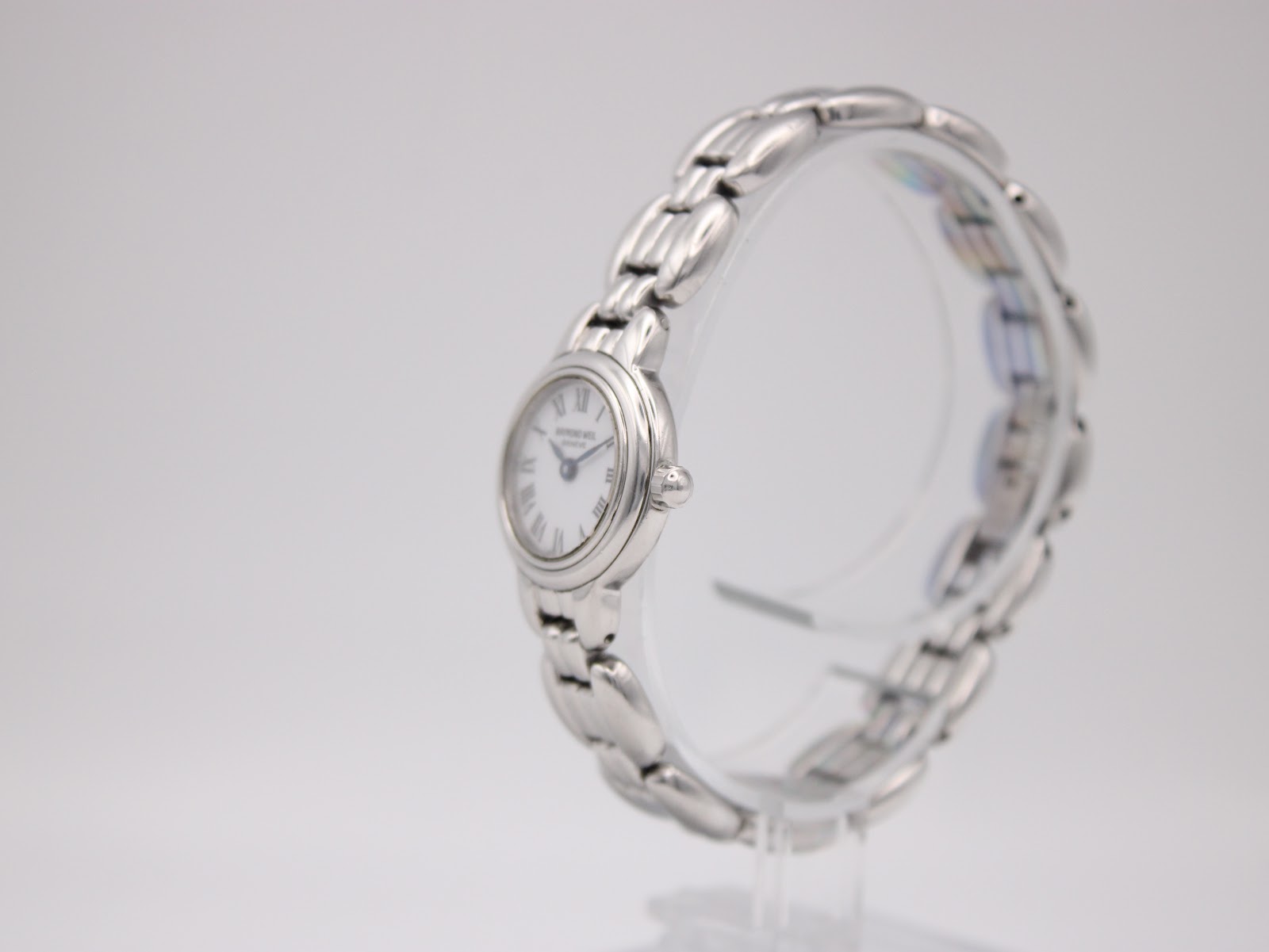 Left angled view of the Raymond Weil 5830 watch, showing the polished stainless steel case and bracelet details.