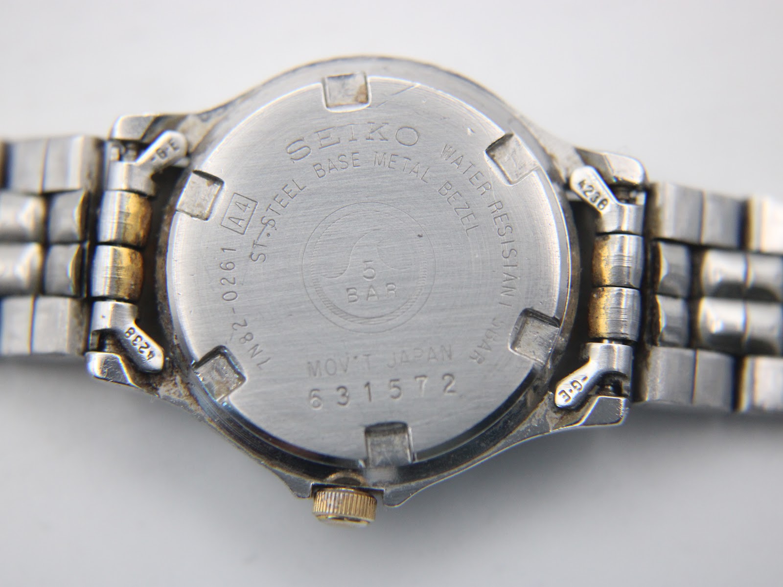 Close-up of the stainless steel case back with Seiko branding, model number 1N82-0261, serial 631572, and water resistance details.