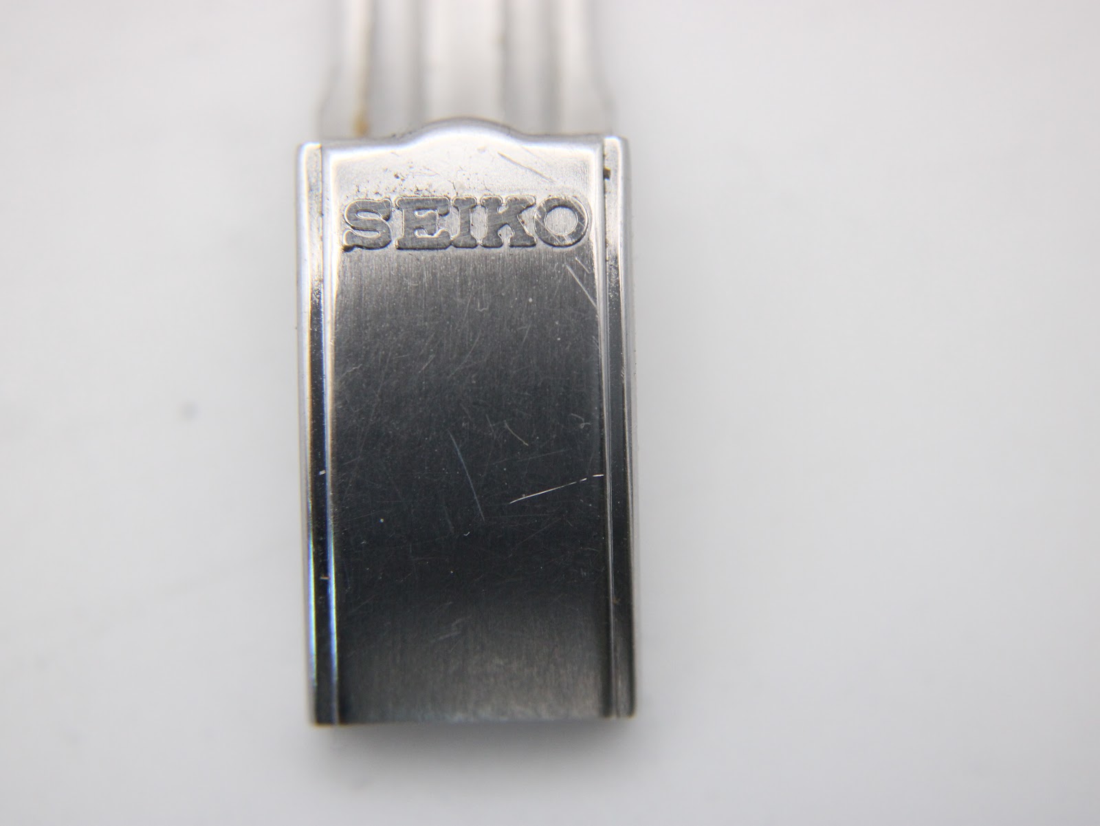 Close-up of the stainless steel fold-over clasp, clearly showing the "SEIKO" logo engraving.