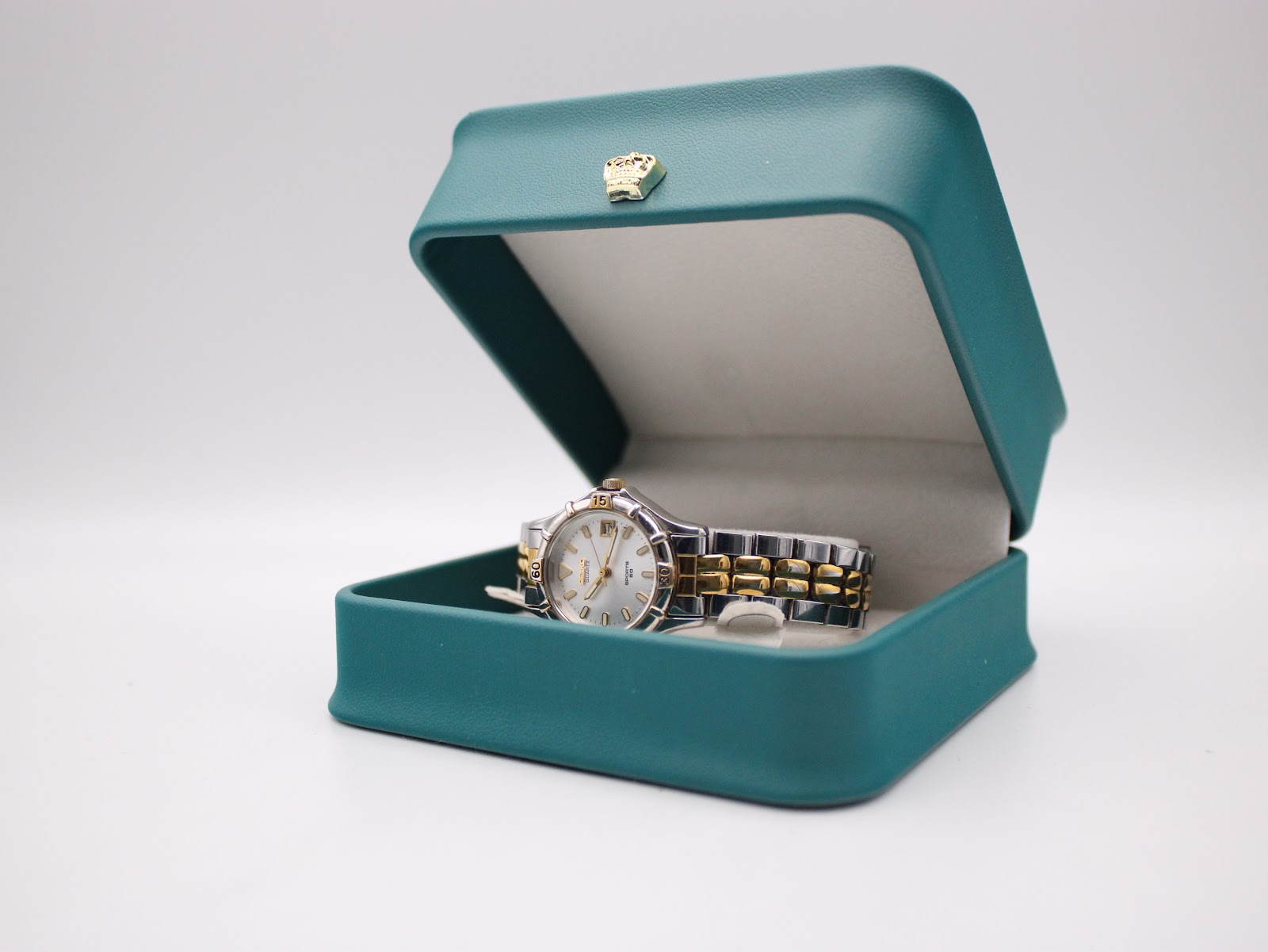 The Seiko watch displayed in a generic teal watch box with a gold crown emblem.