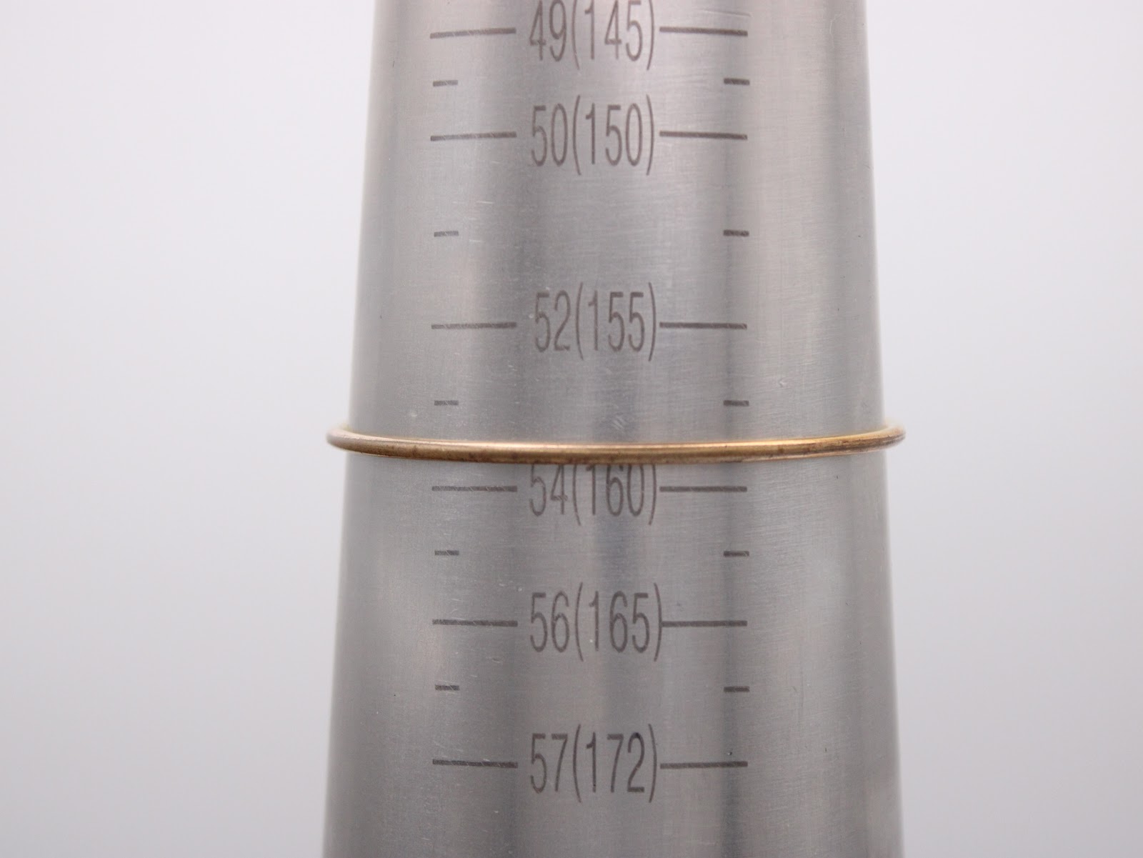 The integrated bangle bracelet being measured on a wrist sizing cone, showing it fits approximately 160mm.