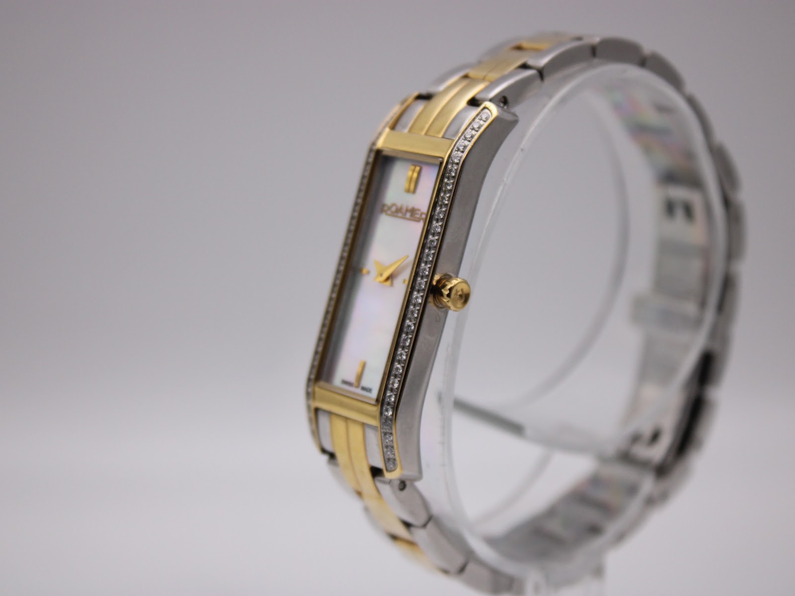 Angled side view of the Roamer Dreamline watch, showing gold crown and crystal-set bezel.