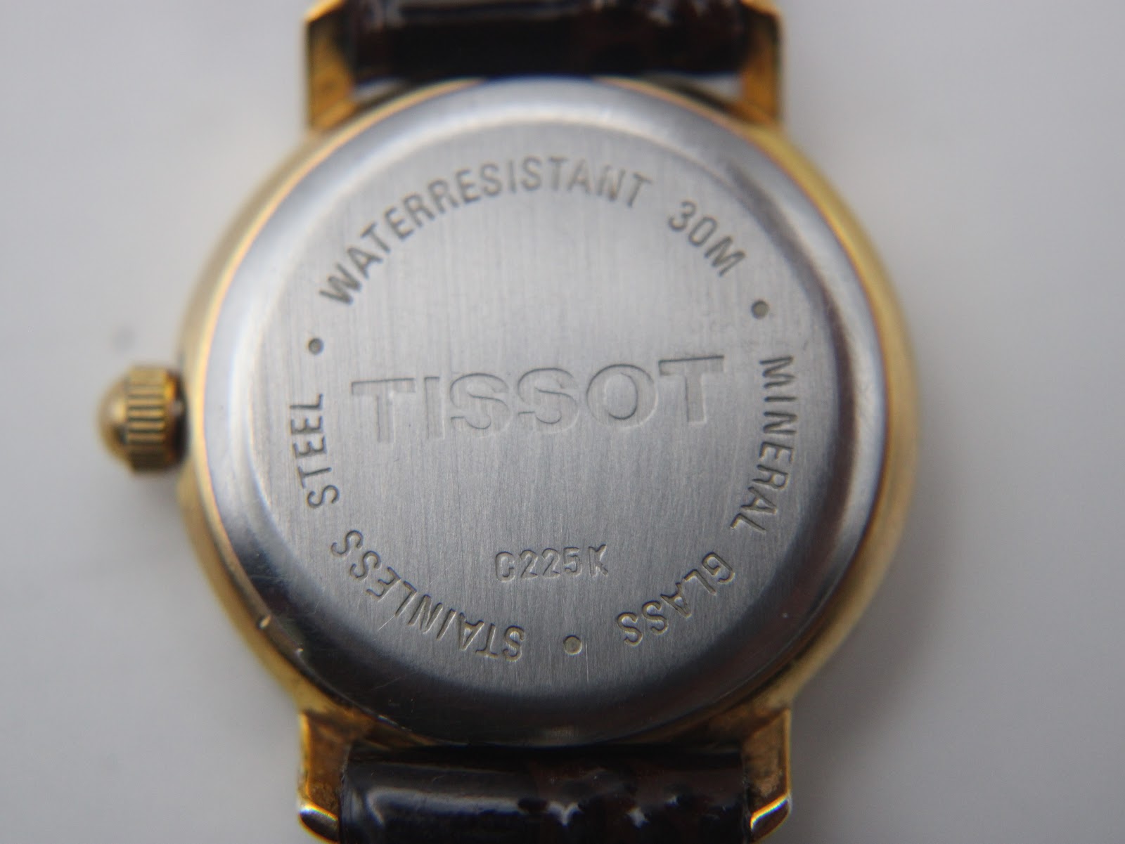 Close-up of the stainless steel case back of the Tissot C225K, showing "Waterresistant 30M", "Tissot", "Mineral Glass", "Stainless Steel", and model "C225K".