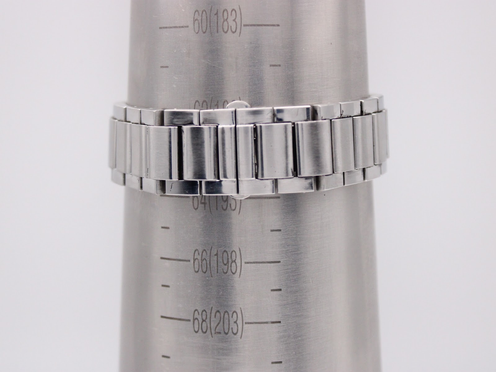 Close-up of the integrated stainless steel bracelet of the Gucci 7700 M watch on a wrist sizing gauge, showing it fits a wrist of approximately 183mm / 18.3cm.