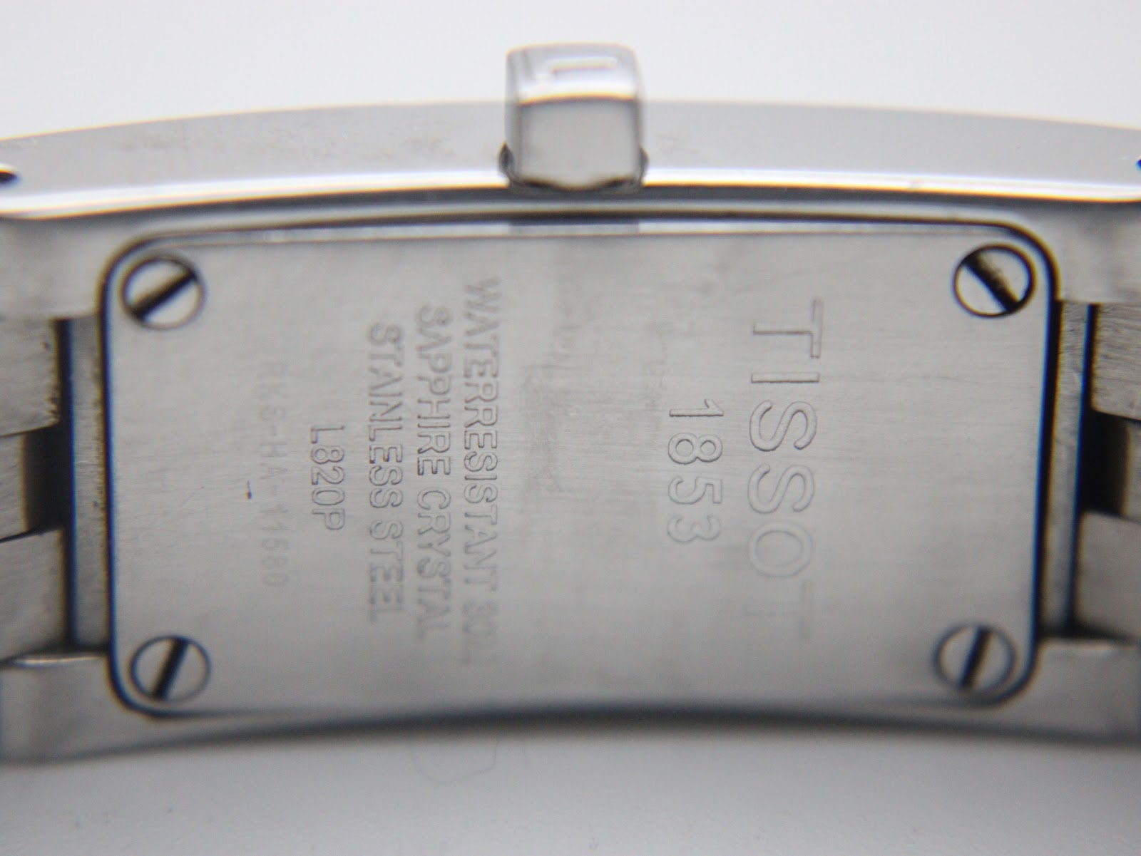 Close-up of the Tissot L820P case back engraving, showing "TISSOT 1853", "Water resistant 30m", "Sapphire crystal", "Stainless steel", "L820P", and serial number "RK6-HA-1180".