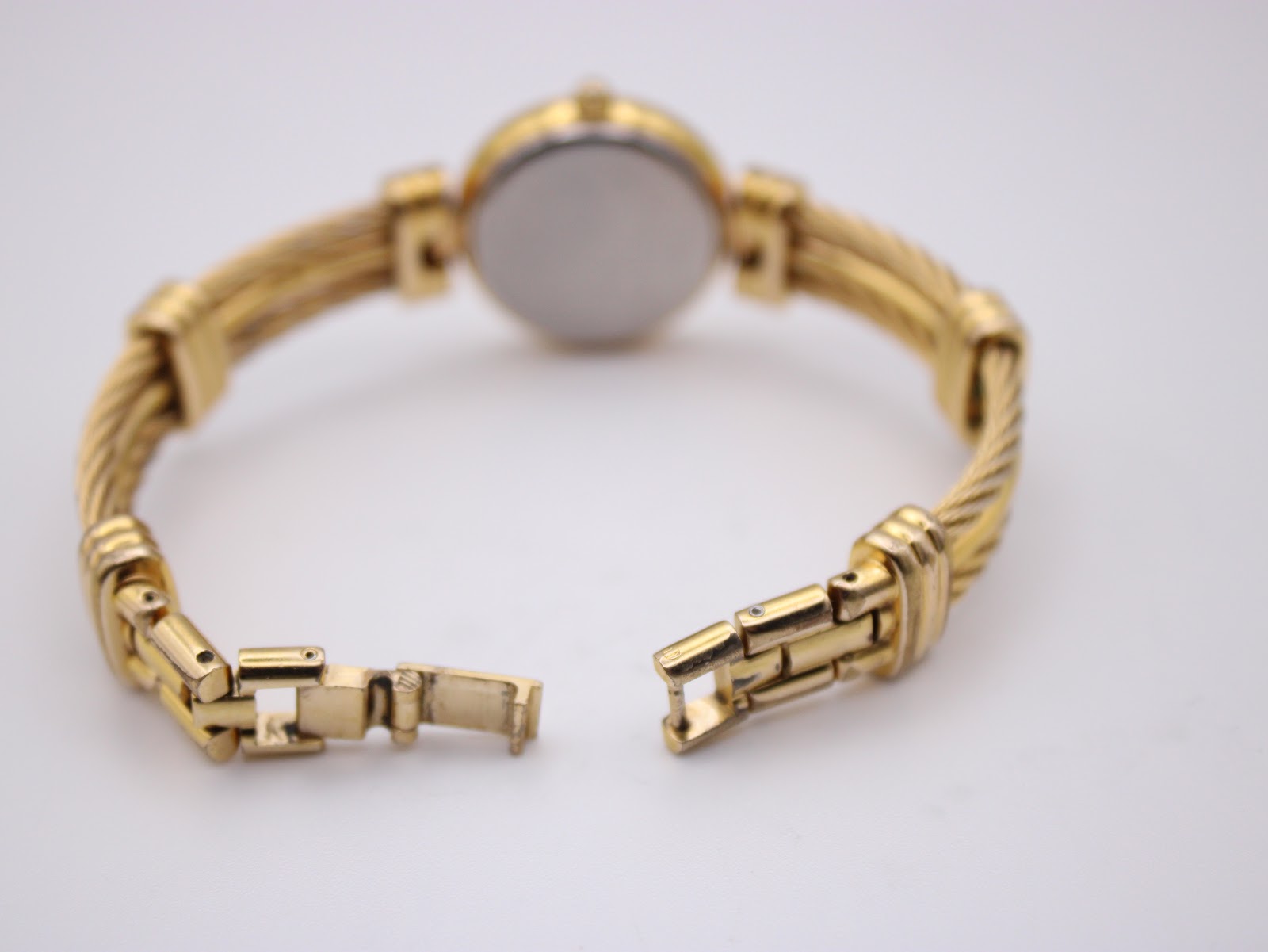 Rear view of the watch with the bracelet unclasped, showing the clasp mechanism and case back.