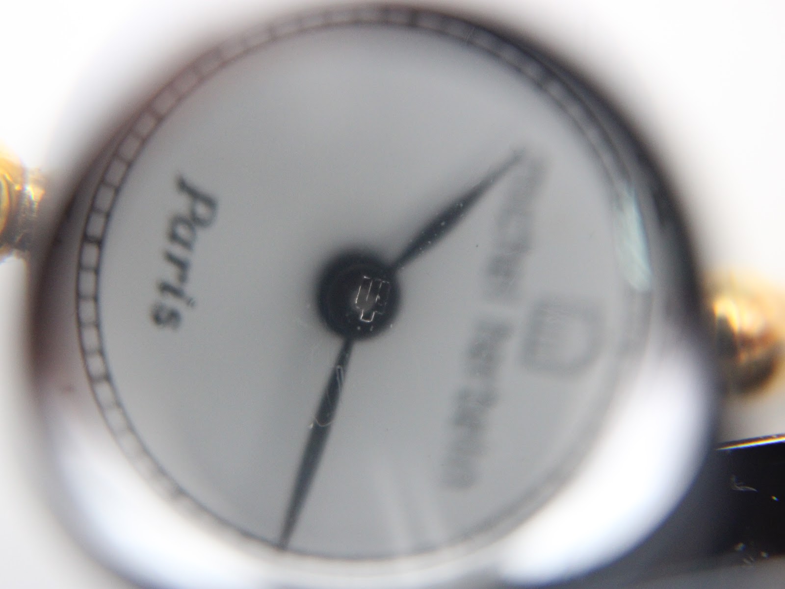 Extreme close-up of the watch dial, showing the Michel Herbelin logo, 'Paris' text, and crisp black Roman numeral hour markers.