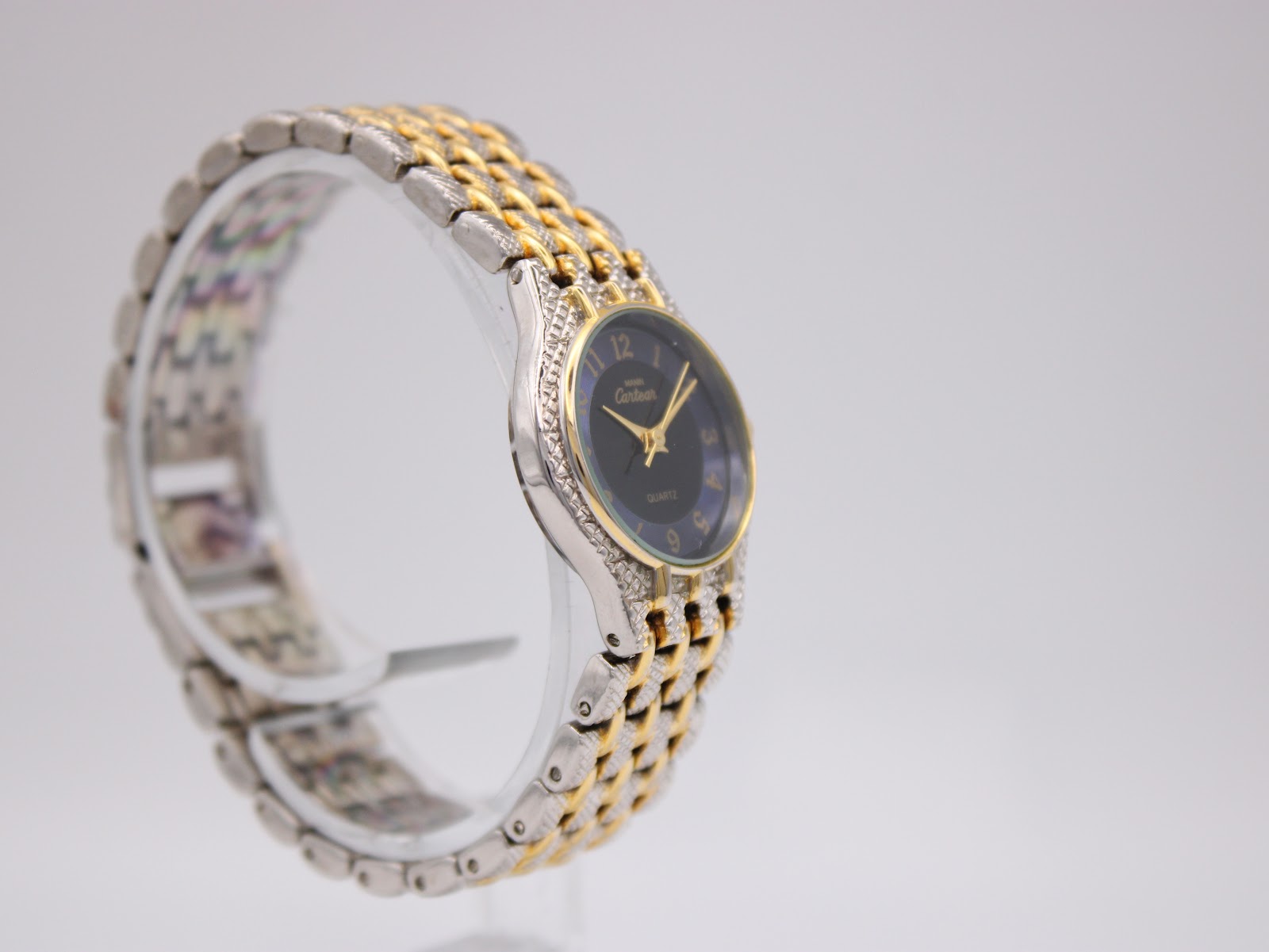 Angled side view of the Manin Cartear watch, highlighting the two-tone bracelet and case profile.