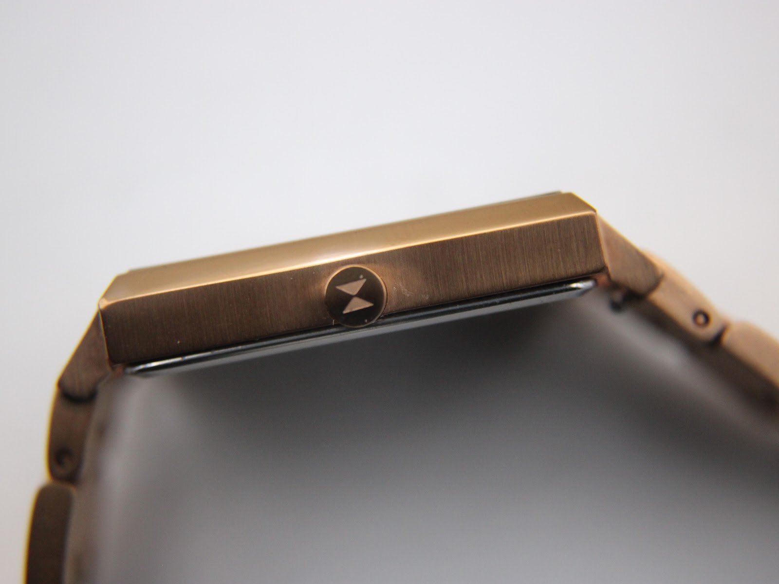 Side profile of the MVMT Signature Square watch case, revealing the signed crown with the MVMT logo.
