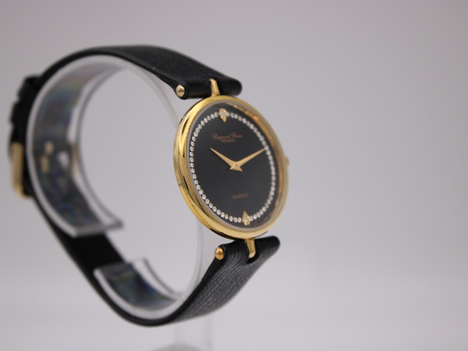 Another angled view of the Raymond Rone Premiere watch, showing the dial and side of the gold-plated case.