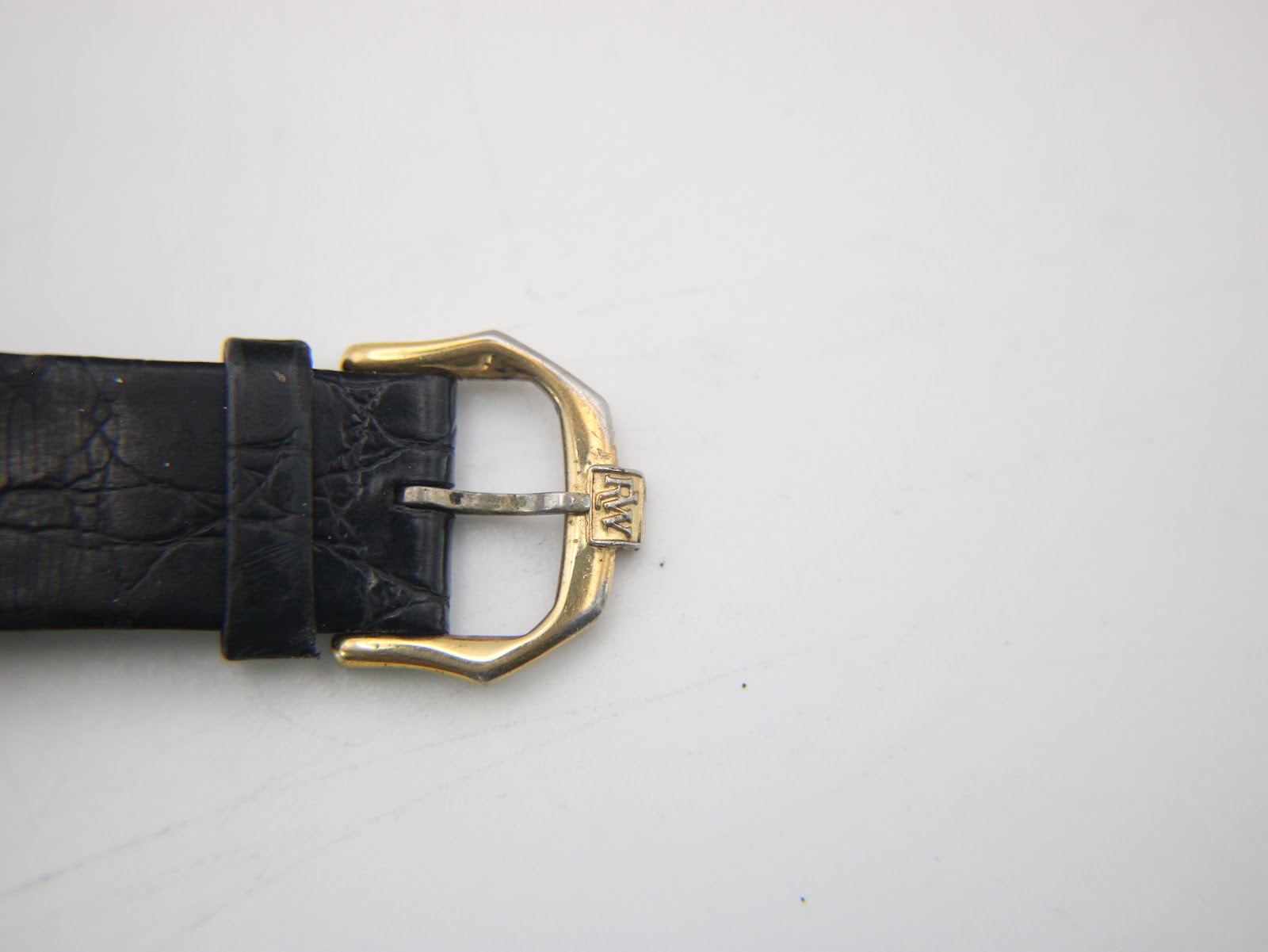 Close-up of the gold-tone buckle with the "RW" logo on the black leather strap.