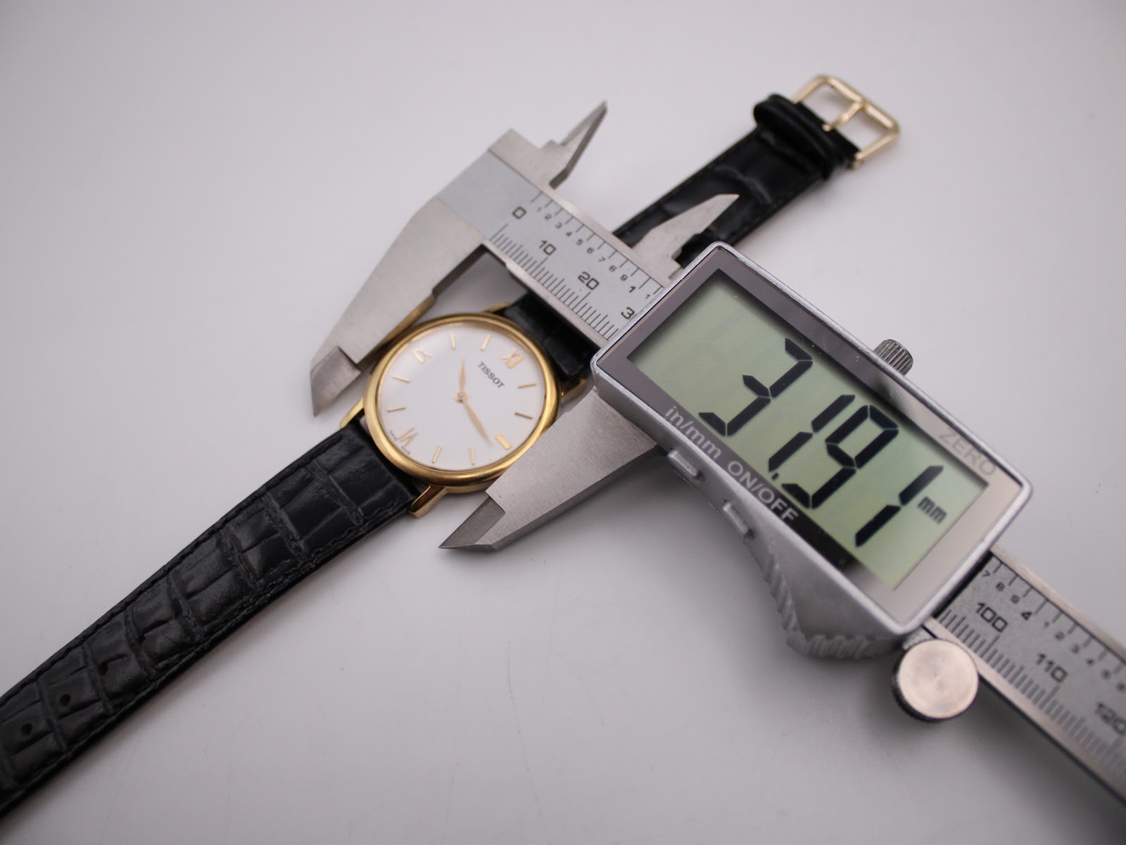 Digital caliper measuring the case diameter of the Tissot watch, displaying 31.9mm.