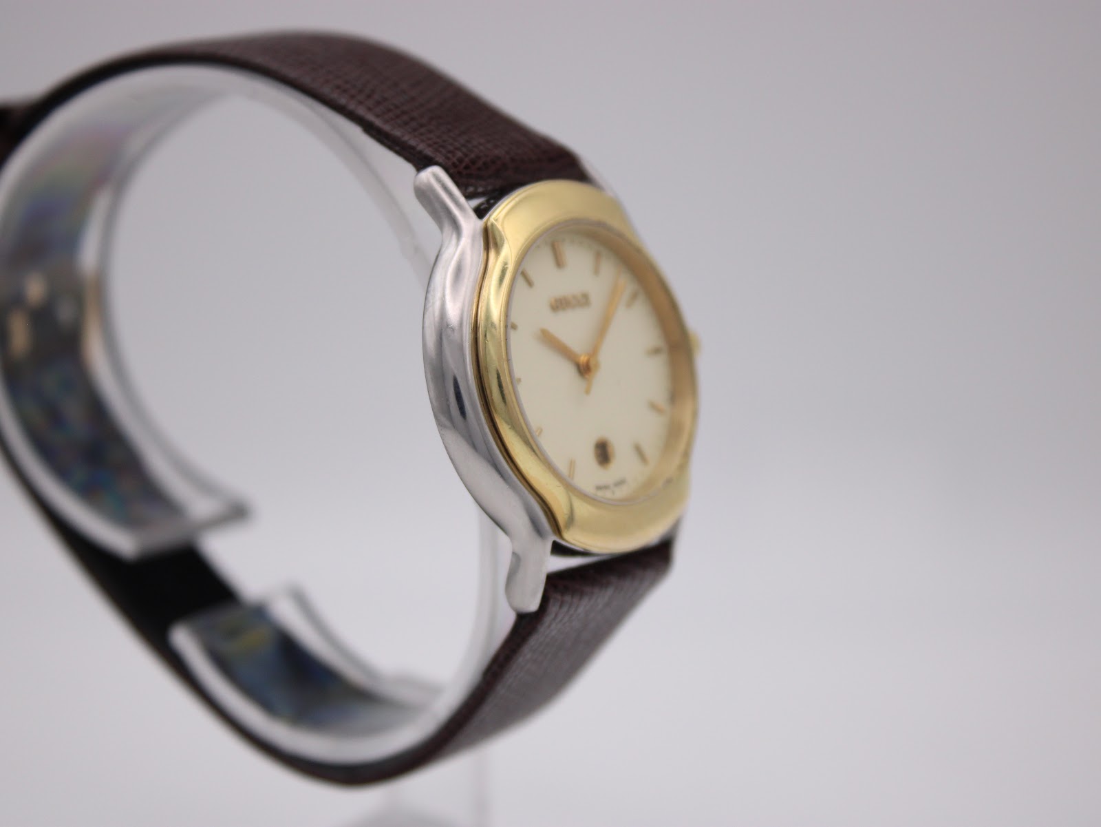 Another angled side view of the watch, highlighting the case profile and brown leather strap from the other side.