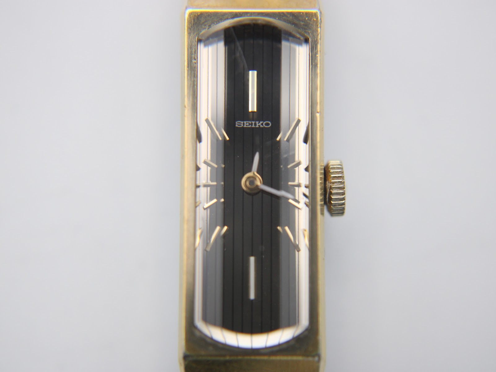 Close-up front view of the Seiko 1520's black dial with vertical brushing, gold baton indices, and 'SEIKO' logo.