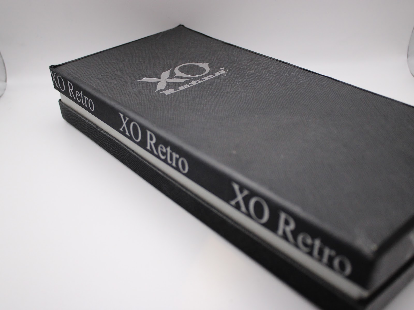 Top view of the black XO RETRO presentation box, showing the brand logo and name printed on the lid.