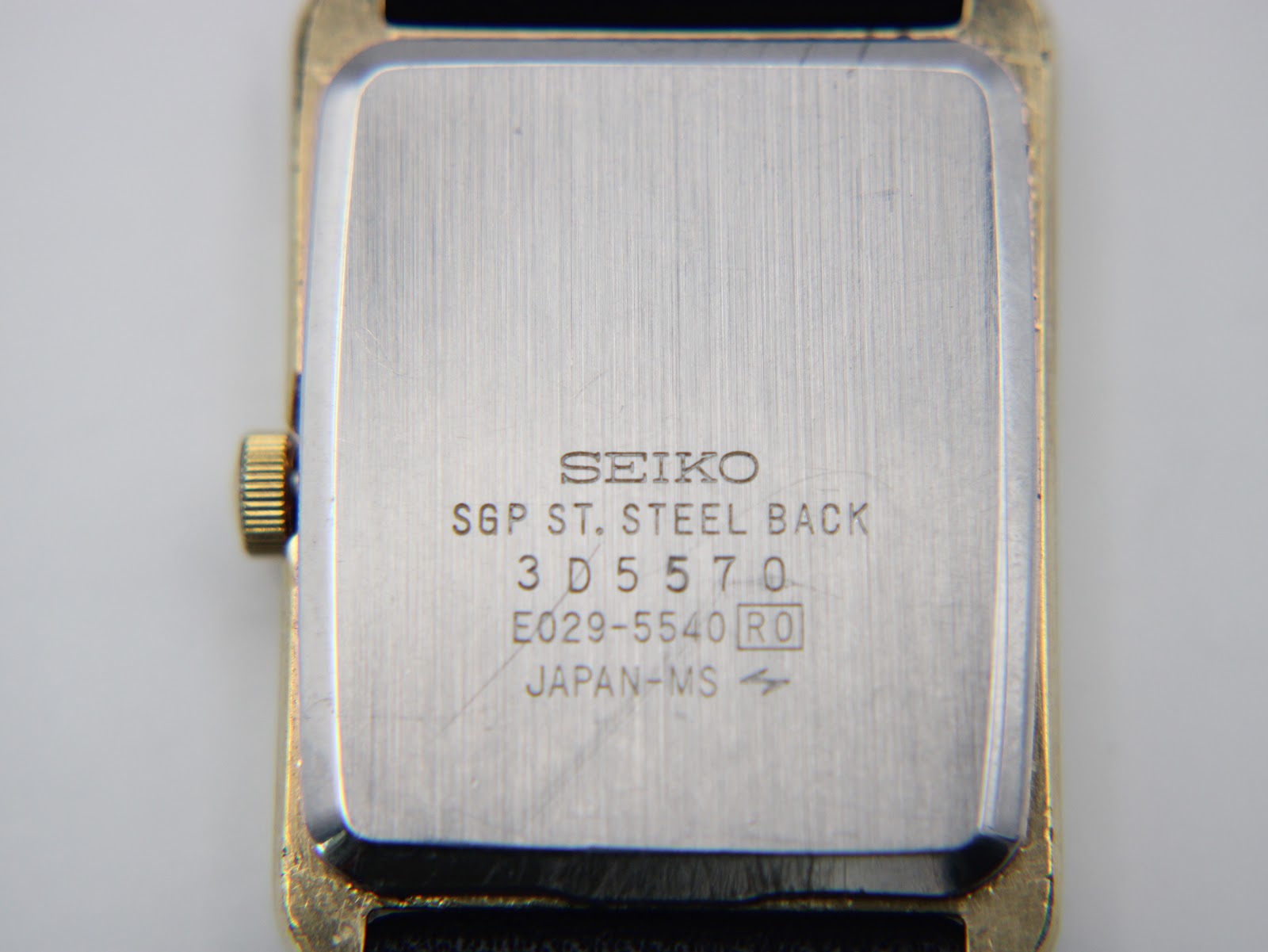 Close-up view of the stainless steel case back of the Seiko watch, with "SEIKO SGP ST. STEEL BACK 3D5570 E029-5540 JAPAN-MS" engravings clearly visible.