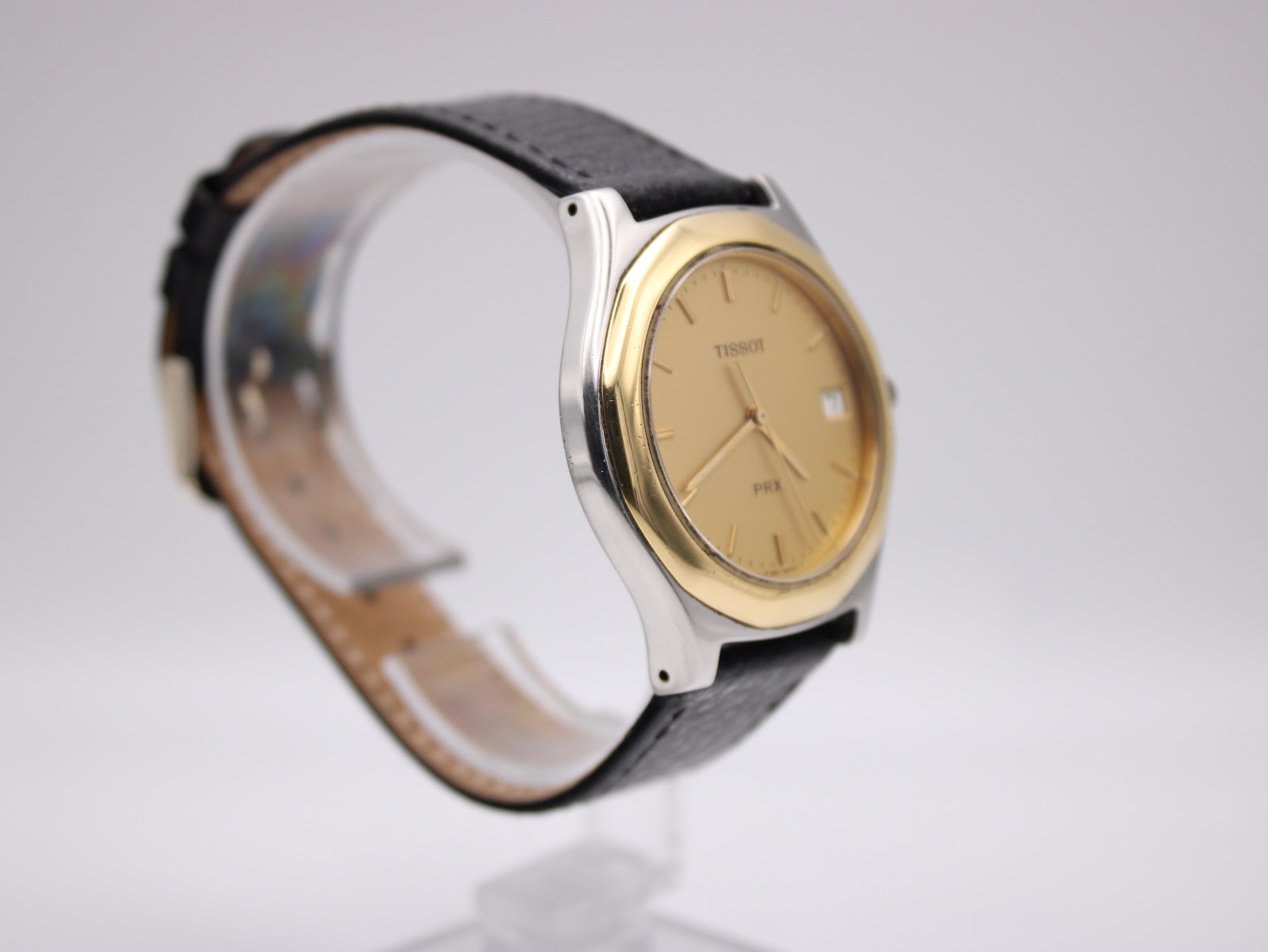 Right side view of the Tissot PRX P380 highlighting the gold-tone bezel and stainless steel case profile.