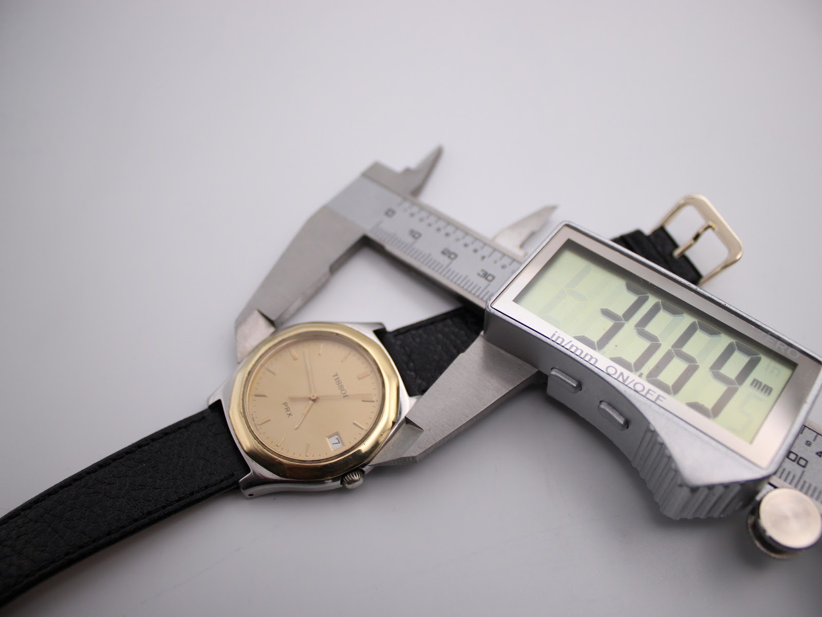Digital caliper measuring the case diameter of the Tissot PRX P380 watch, displaying an exact measurement of 35.69mm.
