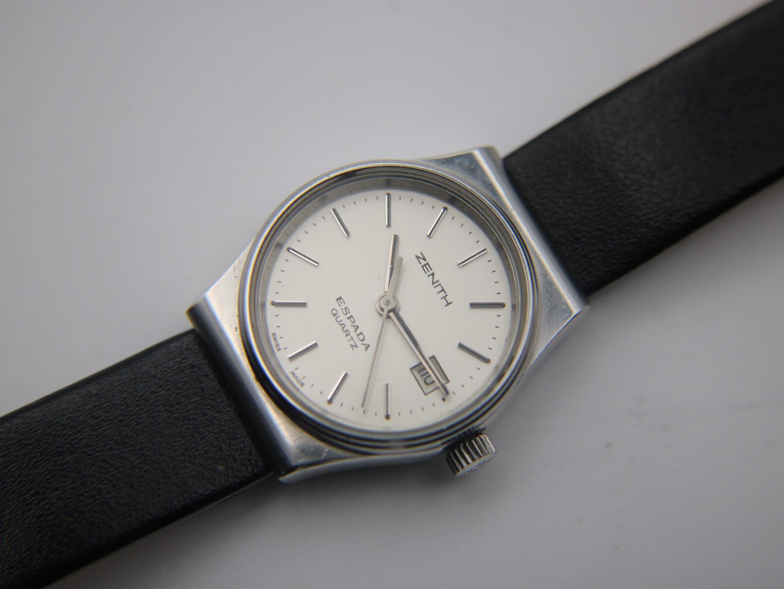 Overhead angled view of the Zenith Espada watch dial, hands, and part of the black leather strap.