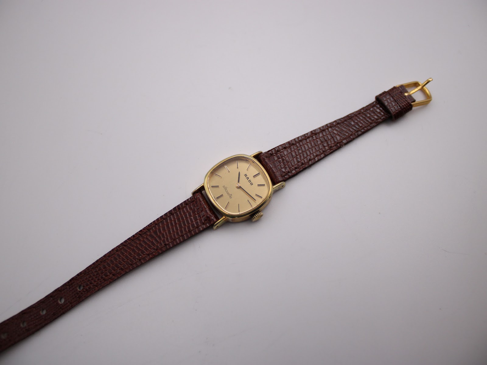 Overhead full view of the Rado Silhouette watch with its brown lizard-grain leather strap fully extended.