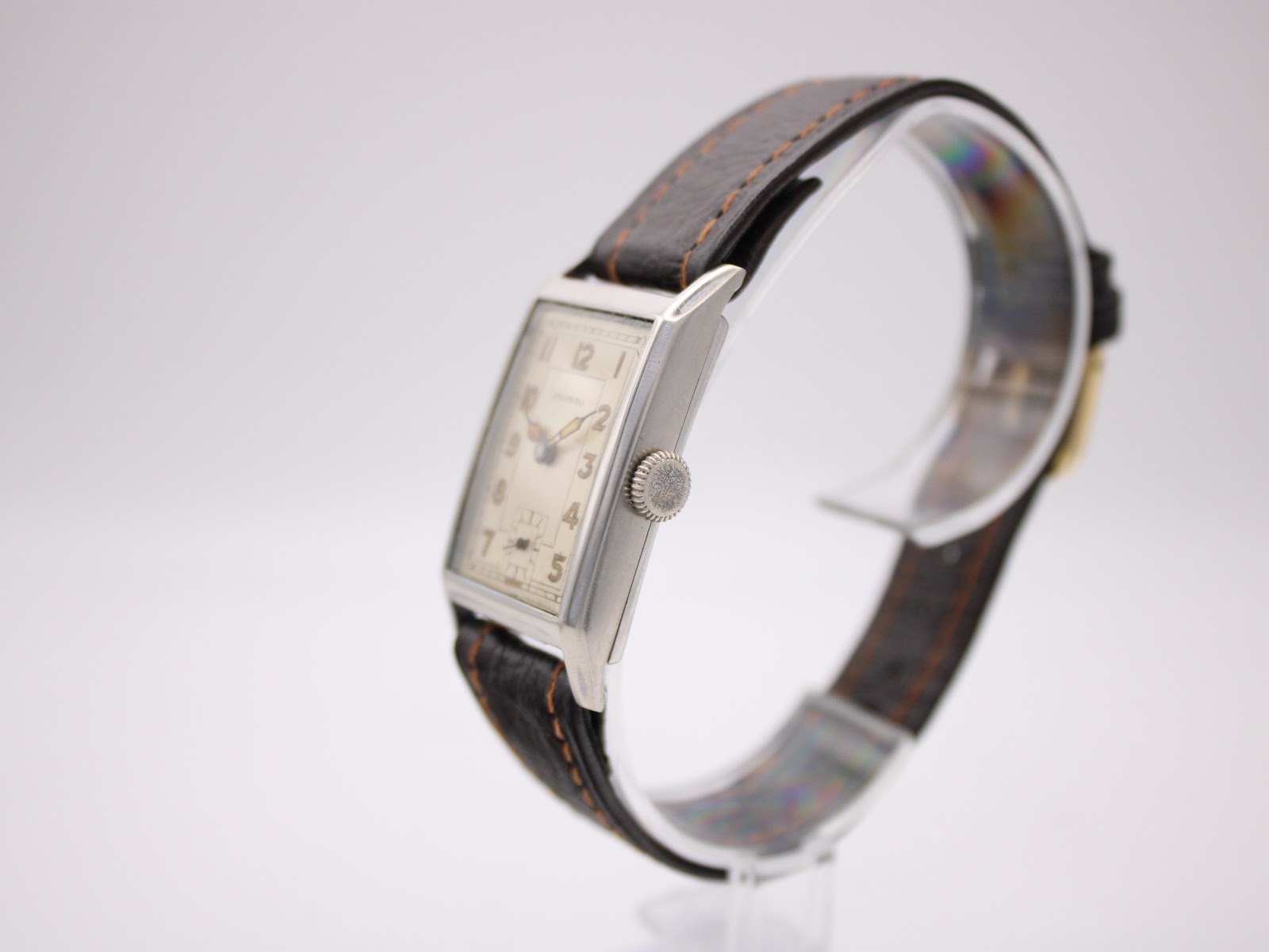 Right-side view of the PRONTO watch showing the crown, rectangular silver case, and strap.