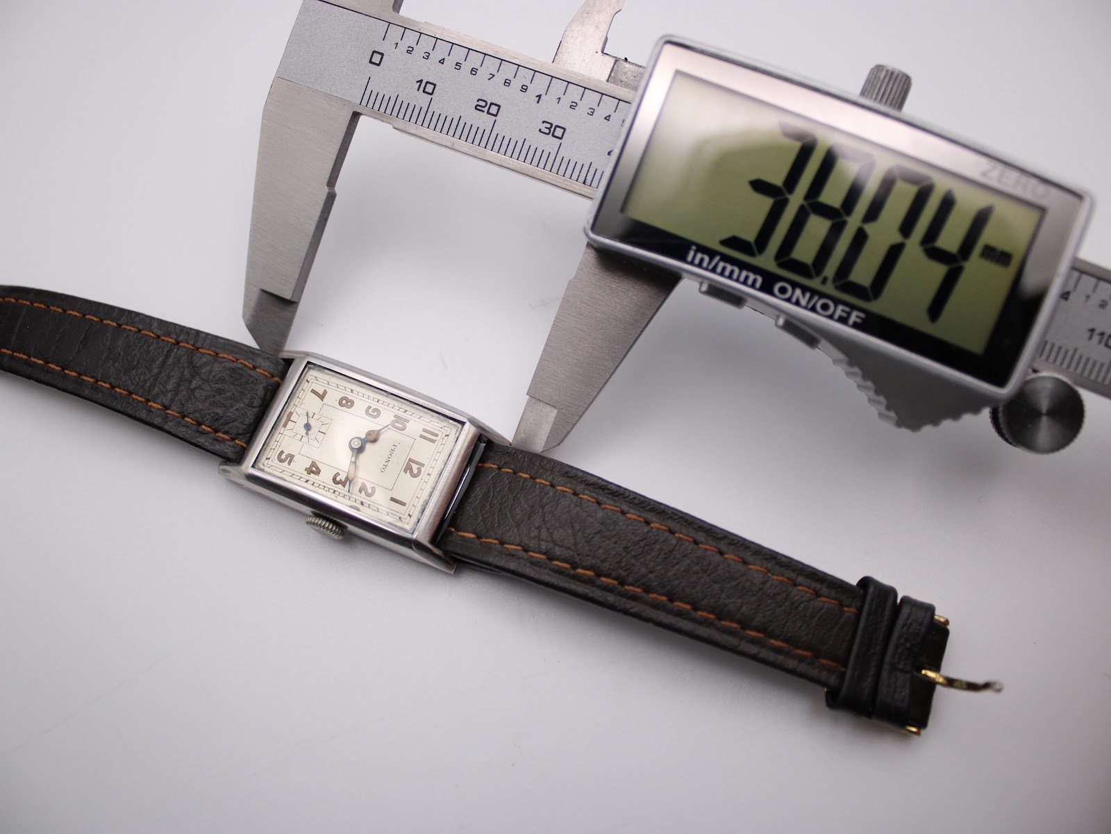Digital caliper measuring the case width (excluding crown) of the PRONTO watch at 22.00mm, showing the brown leather strap.