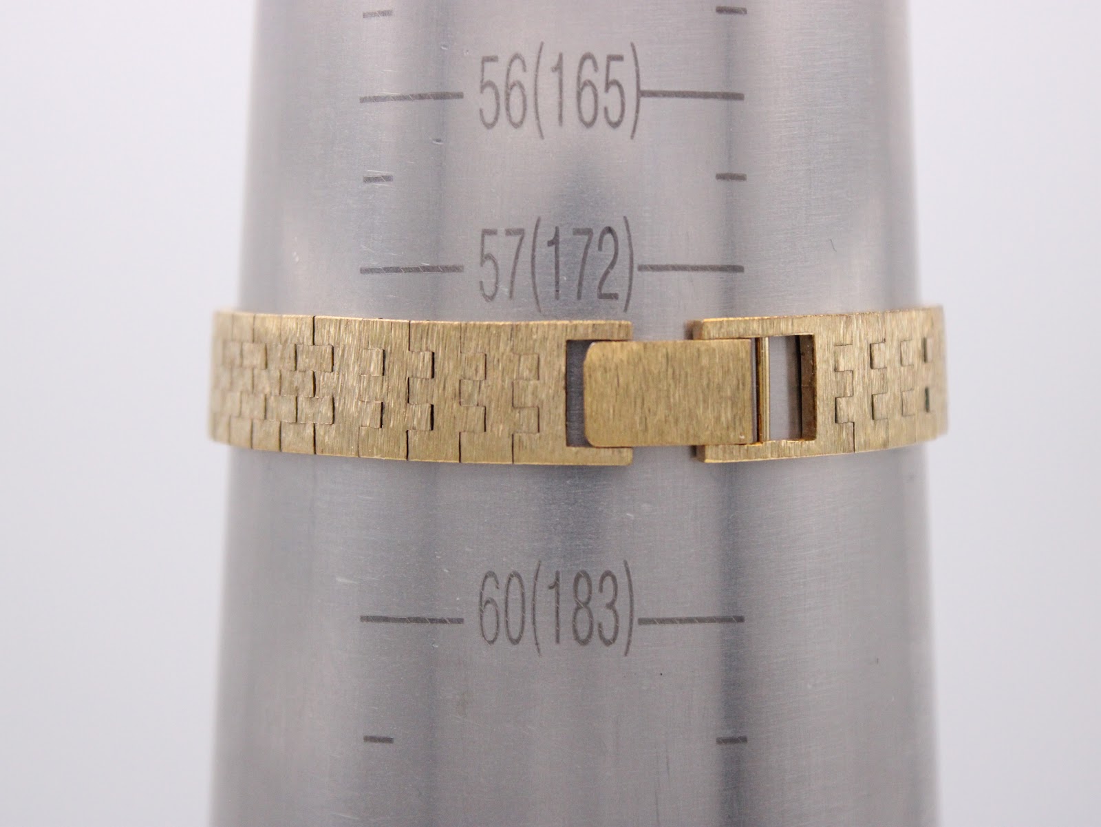 The watch's integrated bracelet wrapped around a metal wrist sizing cone, indicating a wrist circumference of approximately 172mm.
