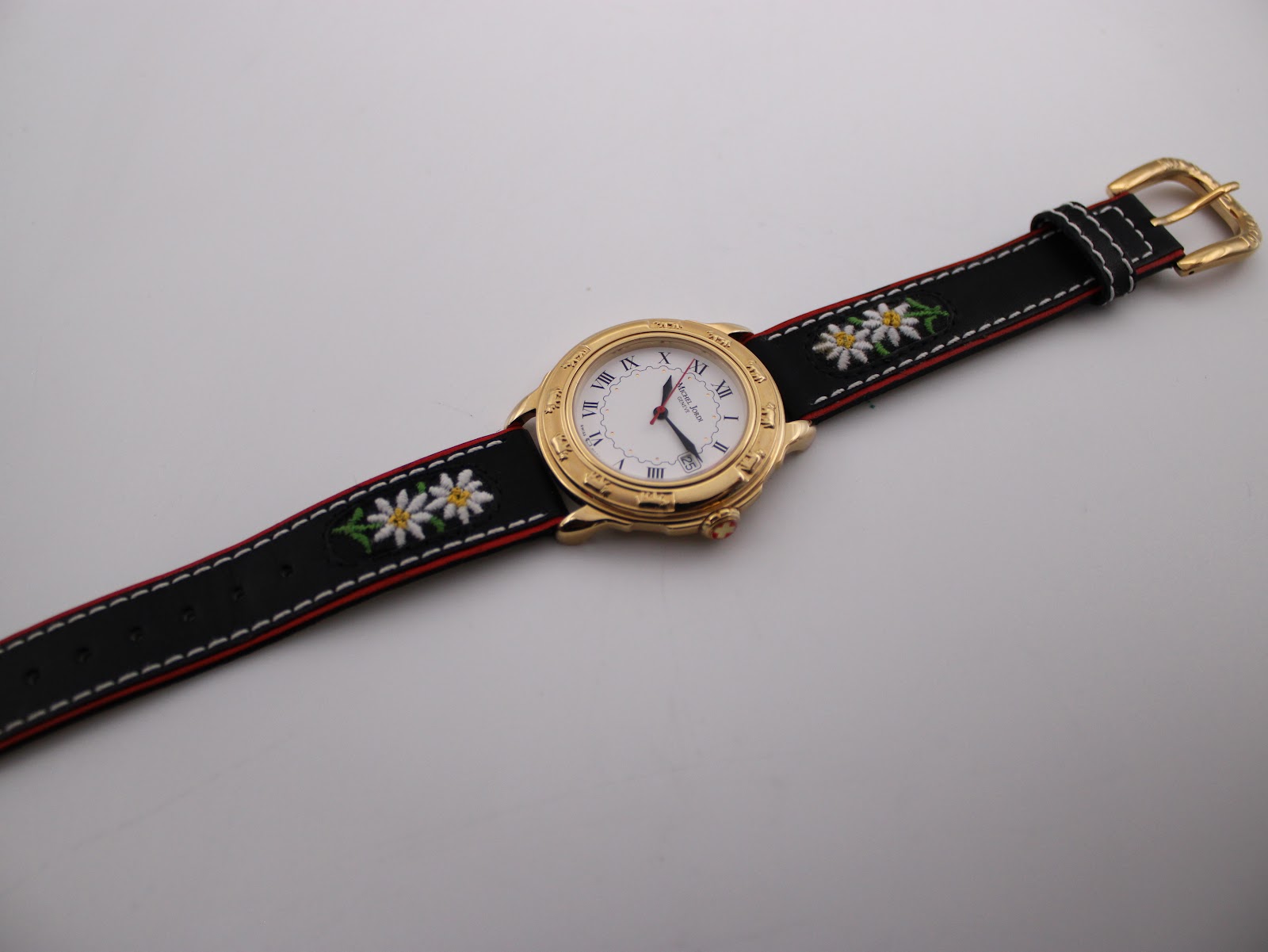 Full overhead view of the Michel Jordi watch on a display stand, highlighting the design of the case and the length of the strap.