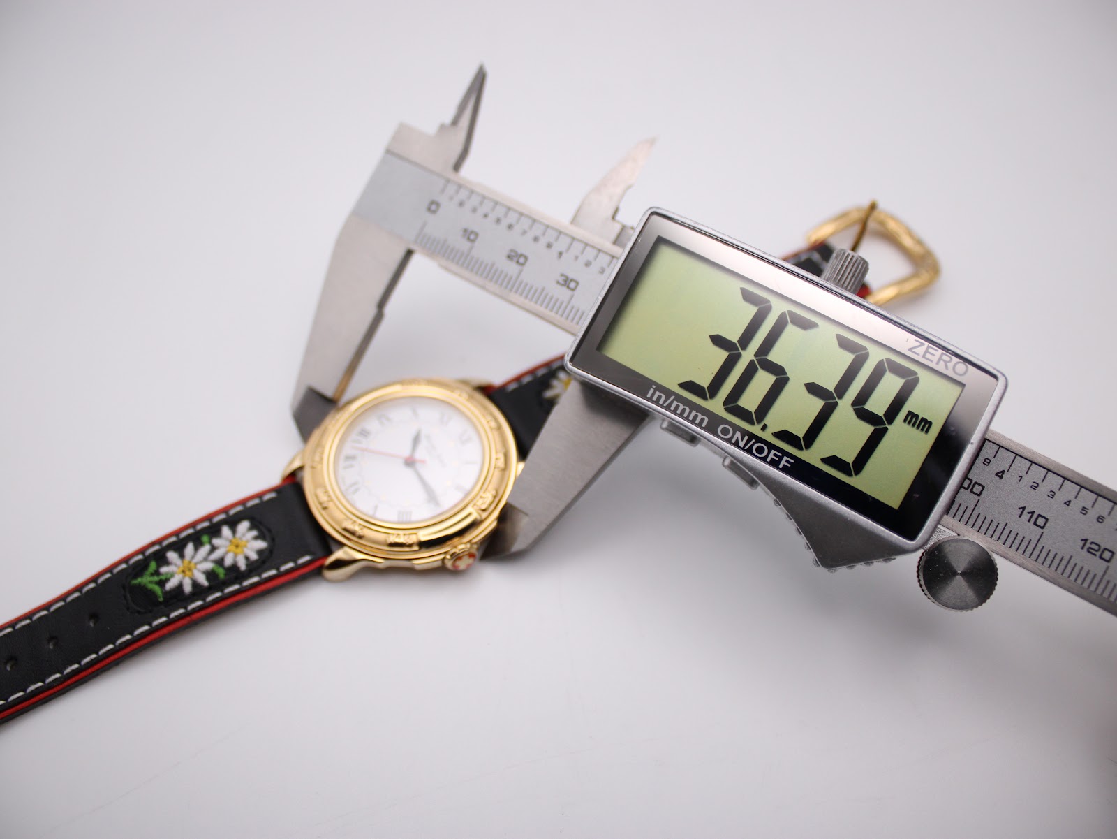 A digital caliper measuring the watch case diameter, displaying an exact measurement of 36.39mm.