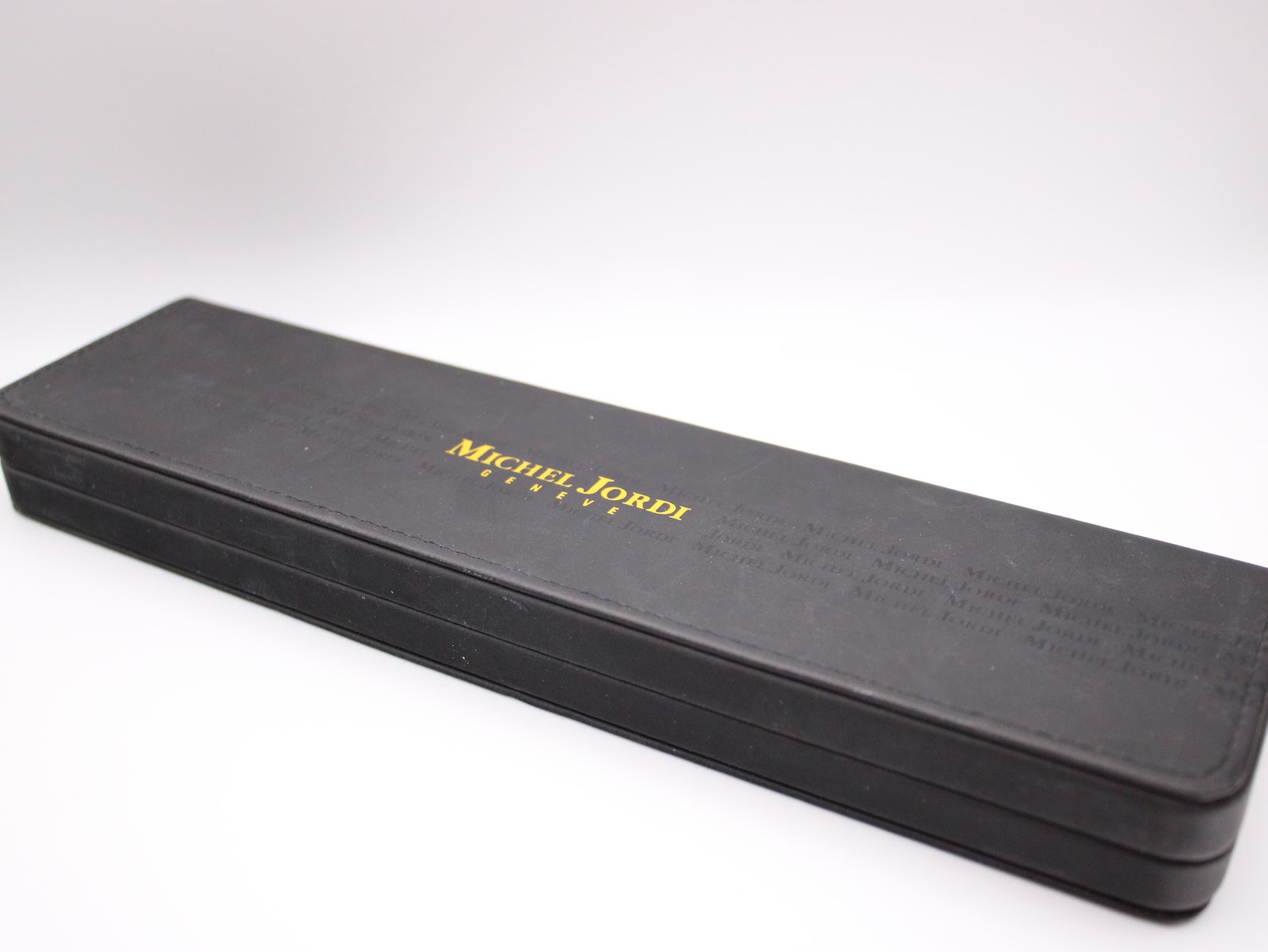 Exterior view of the rectangular black Michel Jordi presentation box with gold branding.