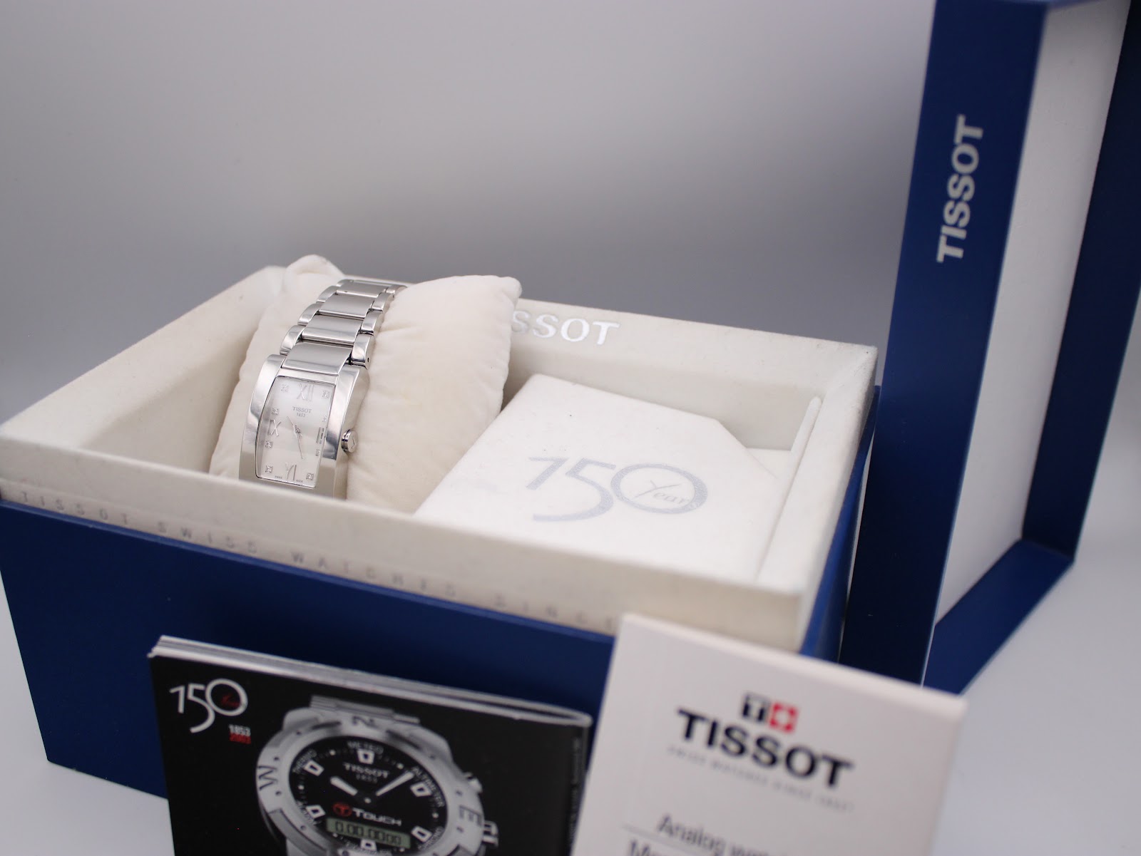 The Tissot watch displayed inside its original blue box with a cream inner cushion and booklets.